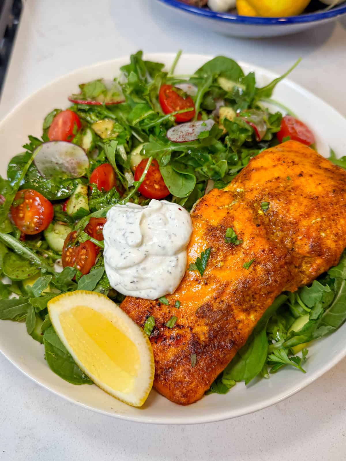Serve the salmon shawarma on top of the fresh salad and garnish with mint yogurt sauce.