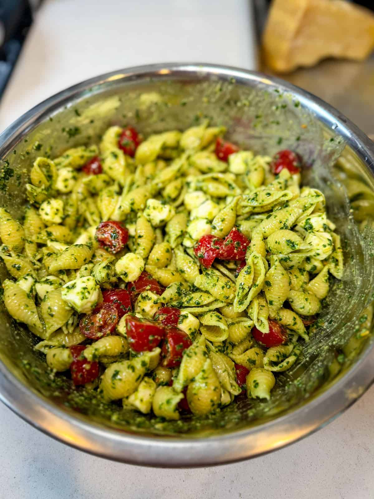 Toss cherry tomatoes and mozarella balls with the pesto pasta. 