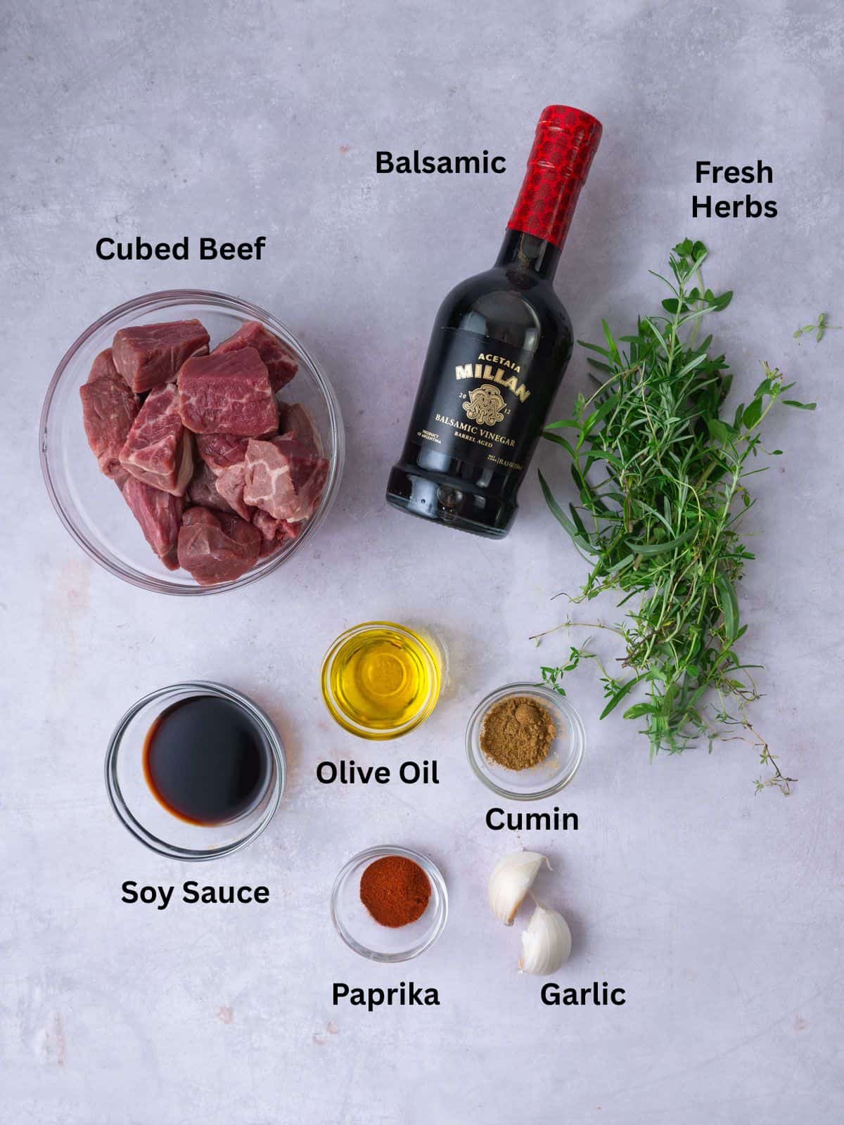 Ingredients for balsamic beef skewers, including fresh herbs, garlic, spices and soy sauce.