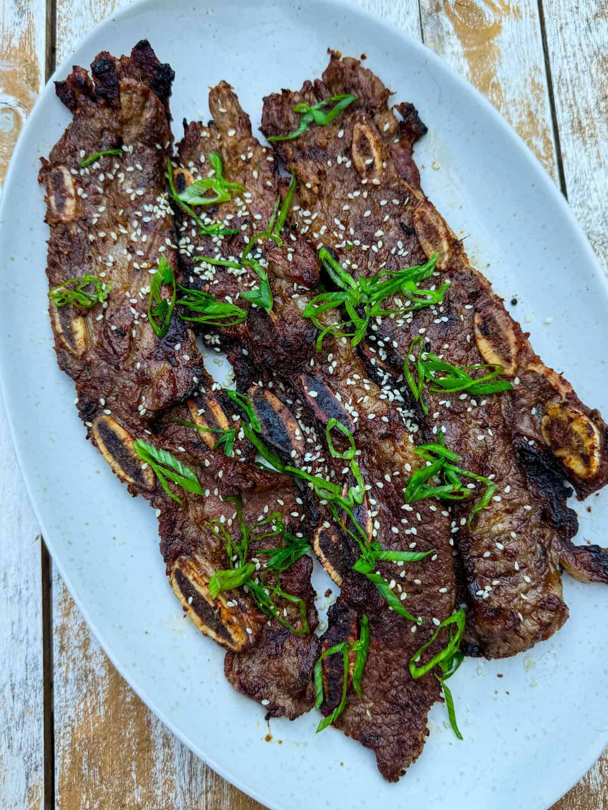 Garnish the Korean short ribs with green onion and sesame seeds.