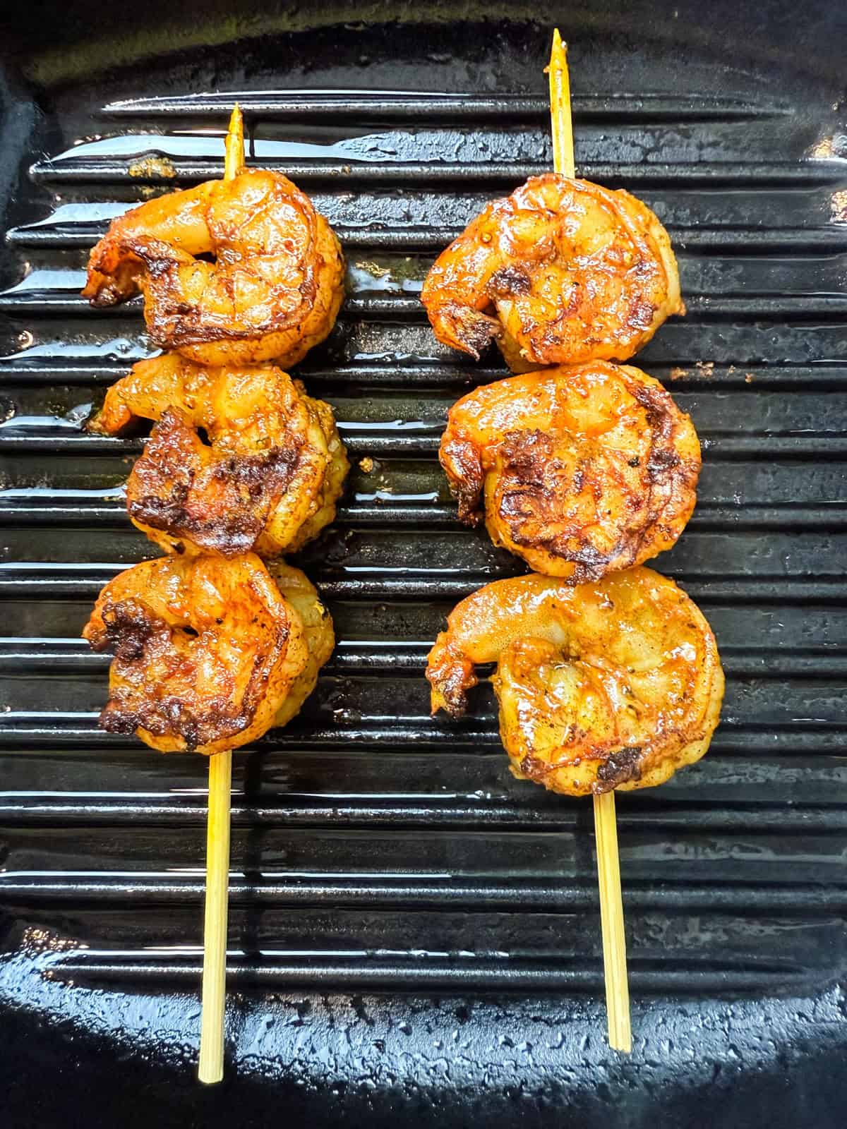 Grill the shrimp skewers until charred on the outside and just cooked through.