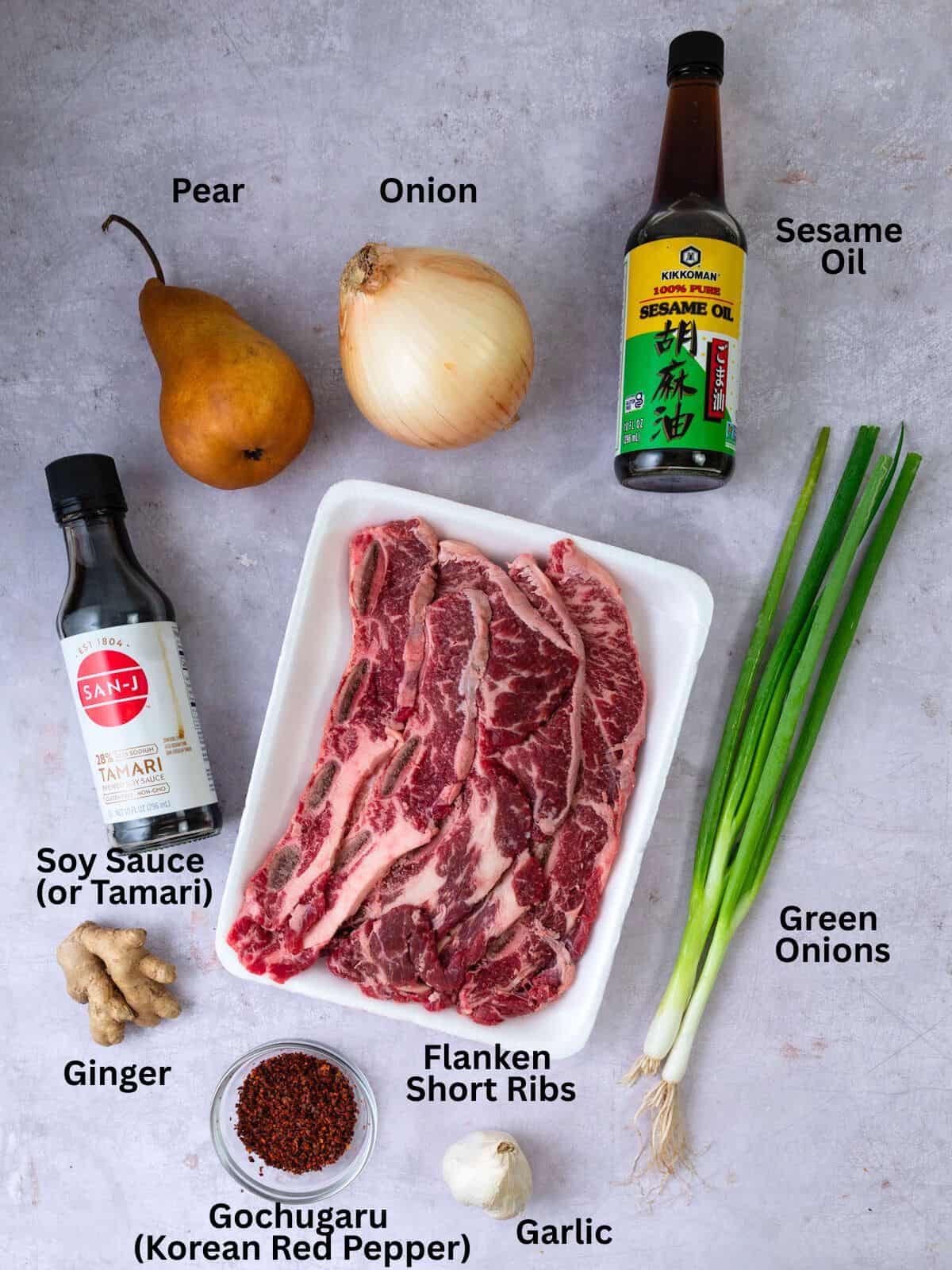 Ingredients for Korean short ribs, including green onion, pear, onion, ginger and garlic.