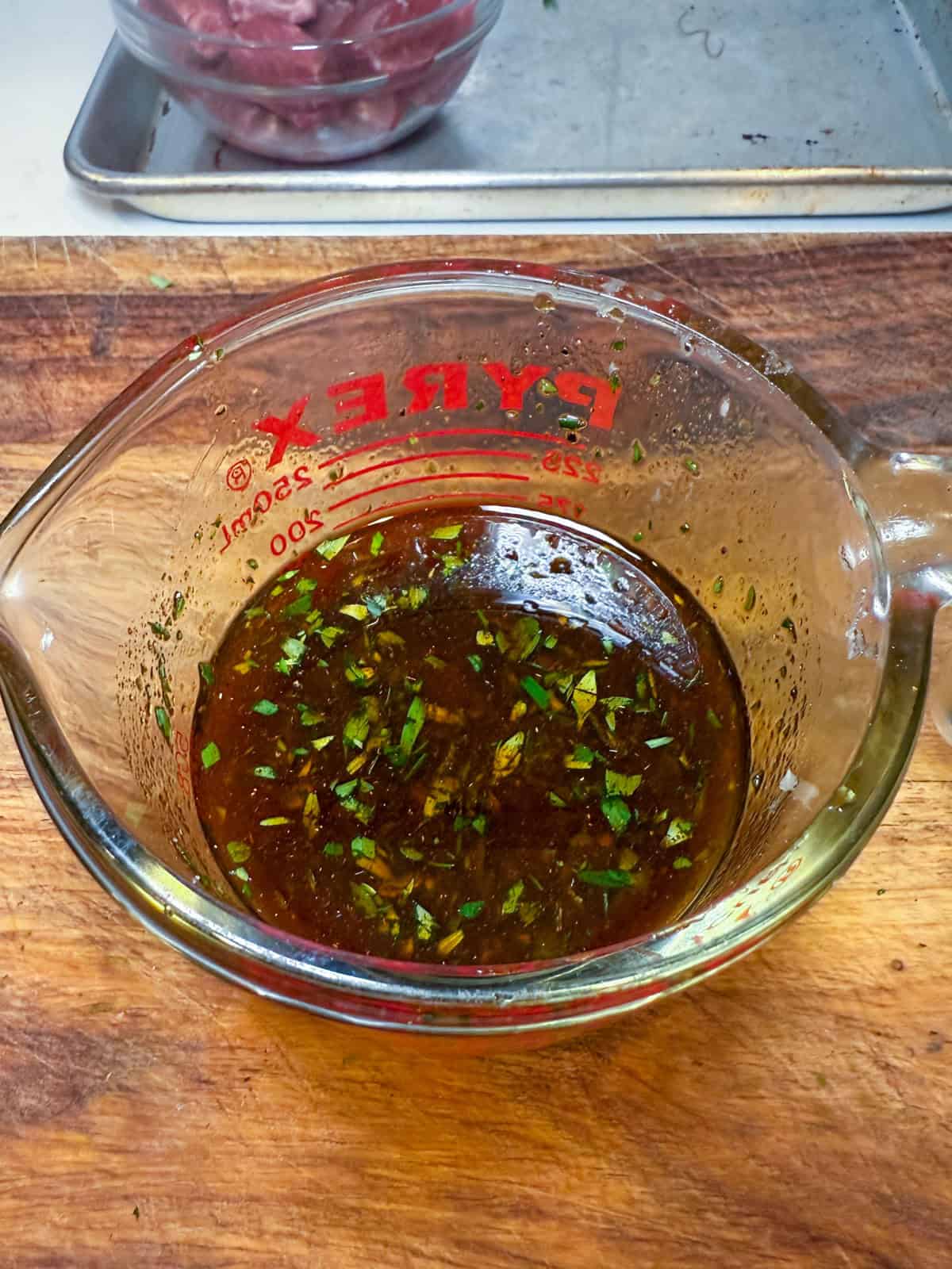 Make the marinade by and whisk together the balsamic, soy sauce, garlic, spices and chopped herbs.