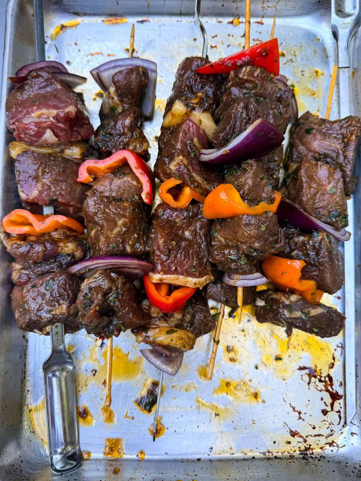 Skewer the marinated cubed beef with onions and peppers onto skewers.