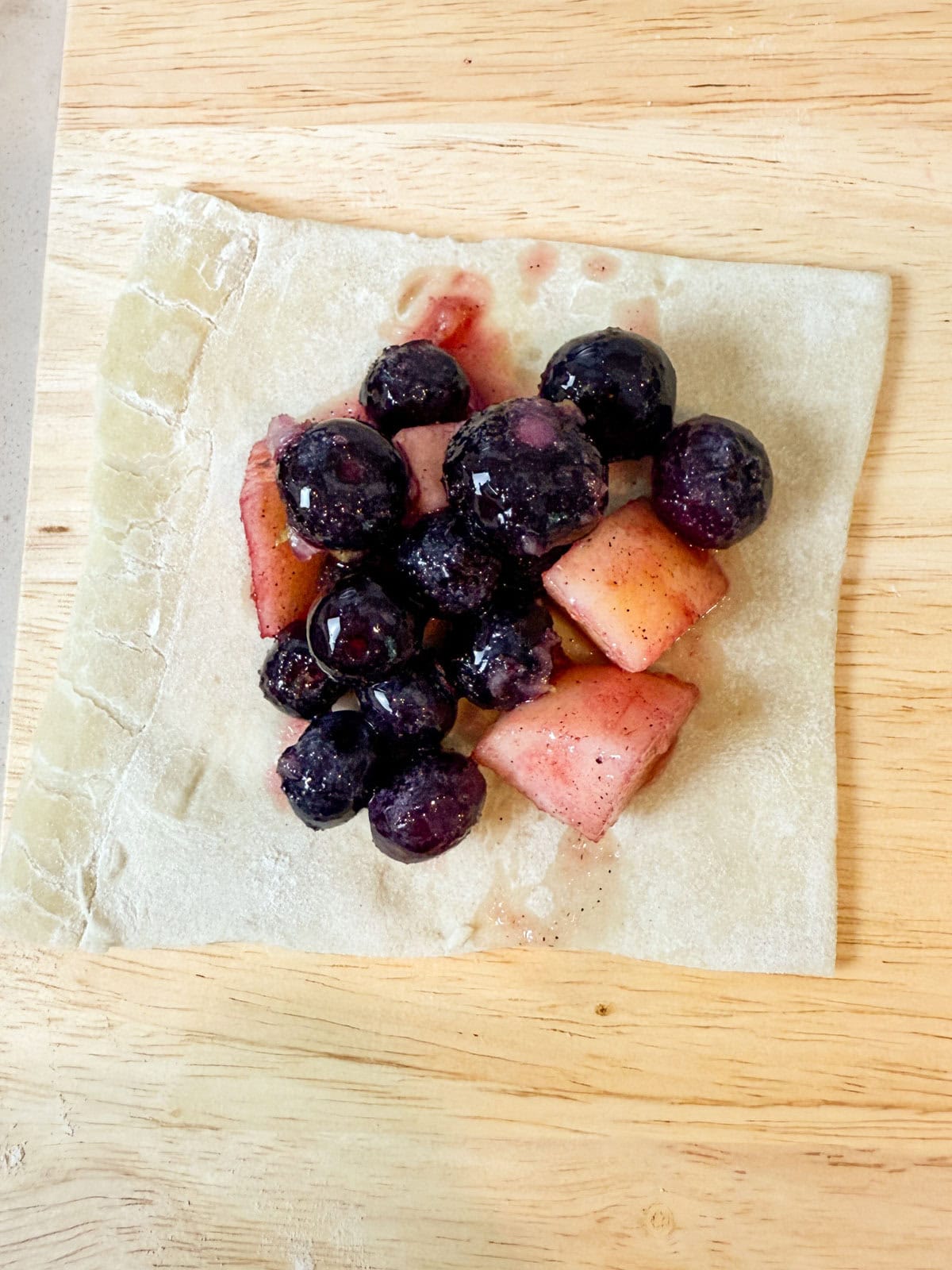 Add the blueberry apple filling to the center of the puff pastry square.