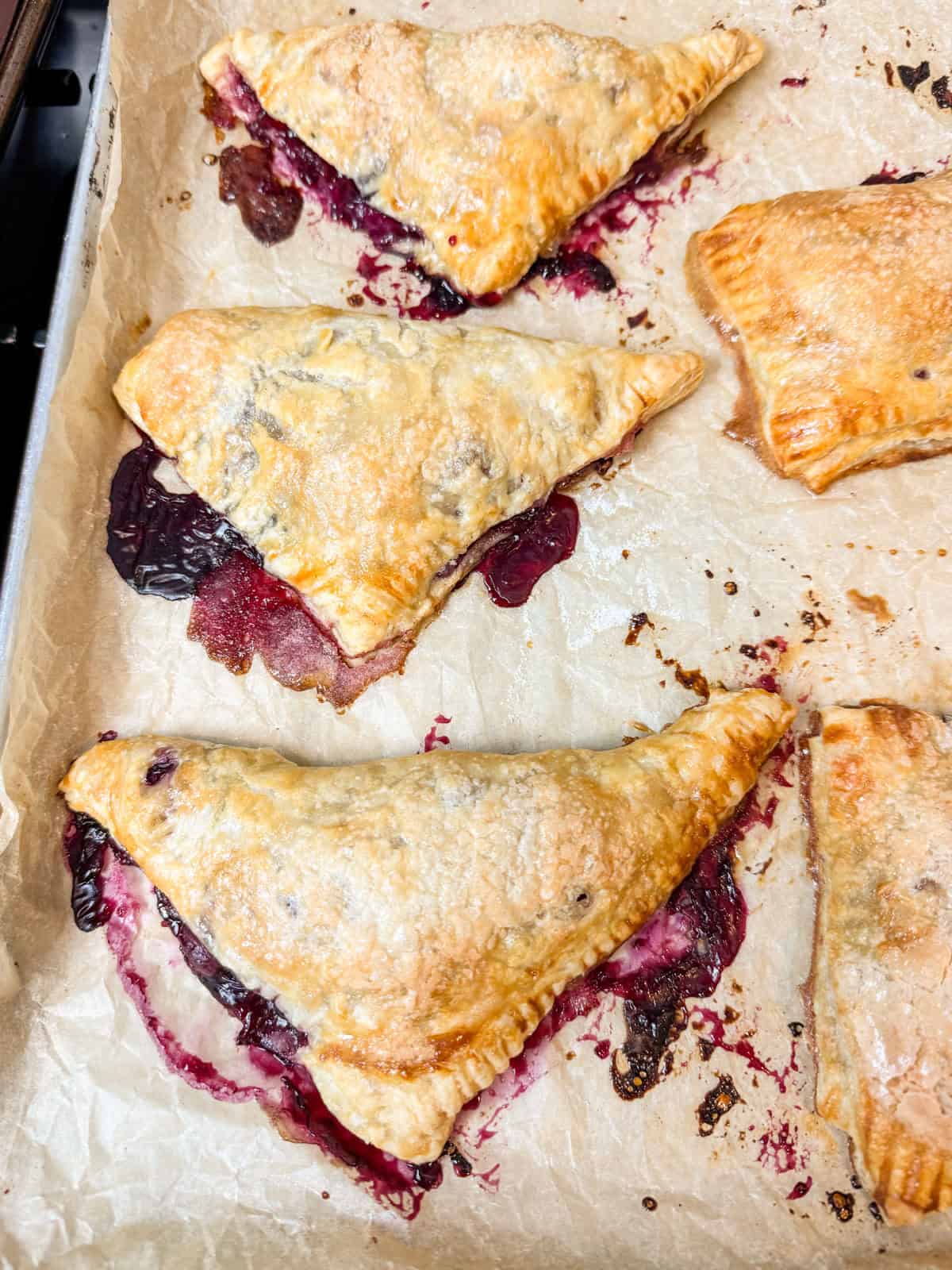 Bake the blueberry bourekas until the puff pastry is puffed and golden brown.