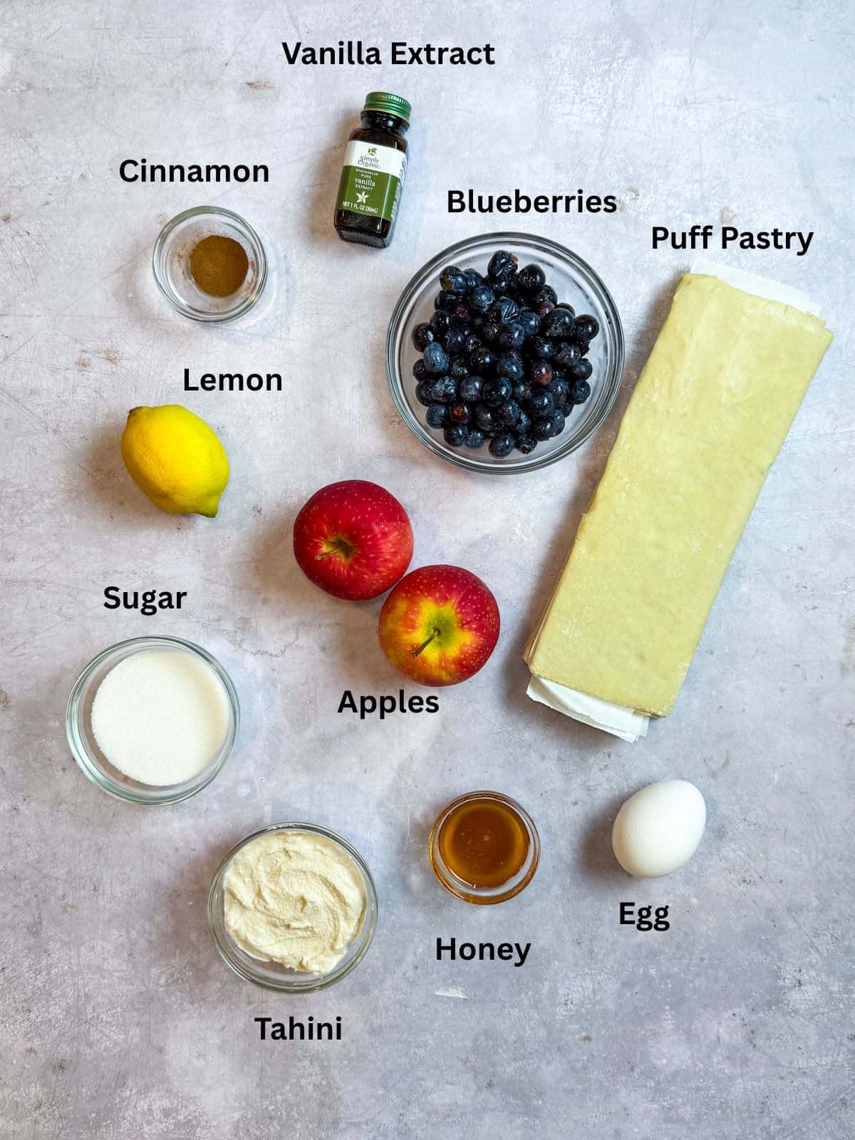 Ingredients for blueberry borekas, with puff pastry, sugar, cinnamon, blueberries and apples.