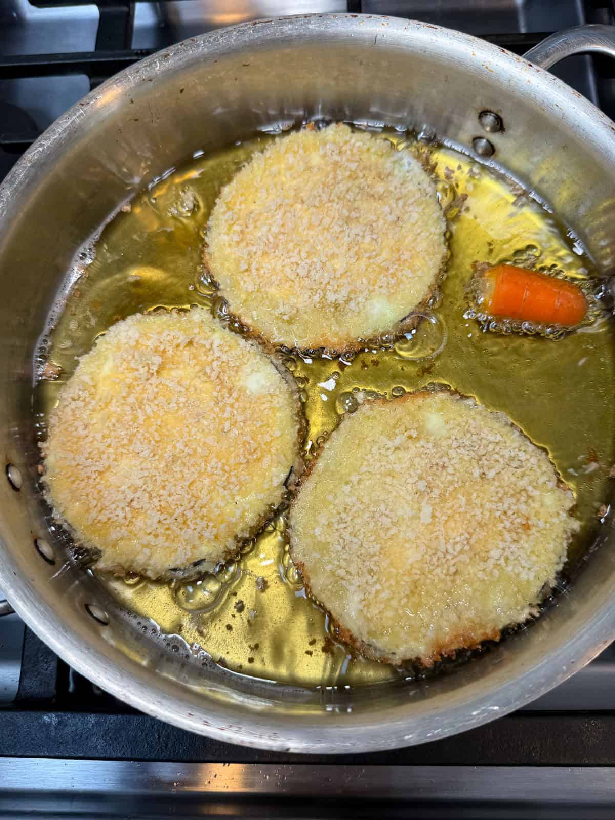 Fry the coated eggplant in hot oil.