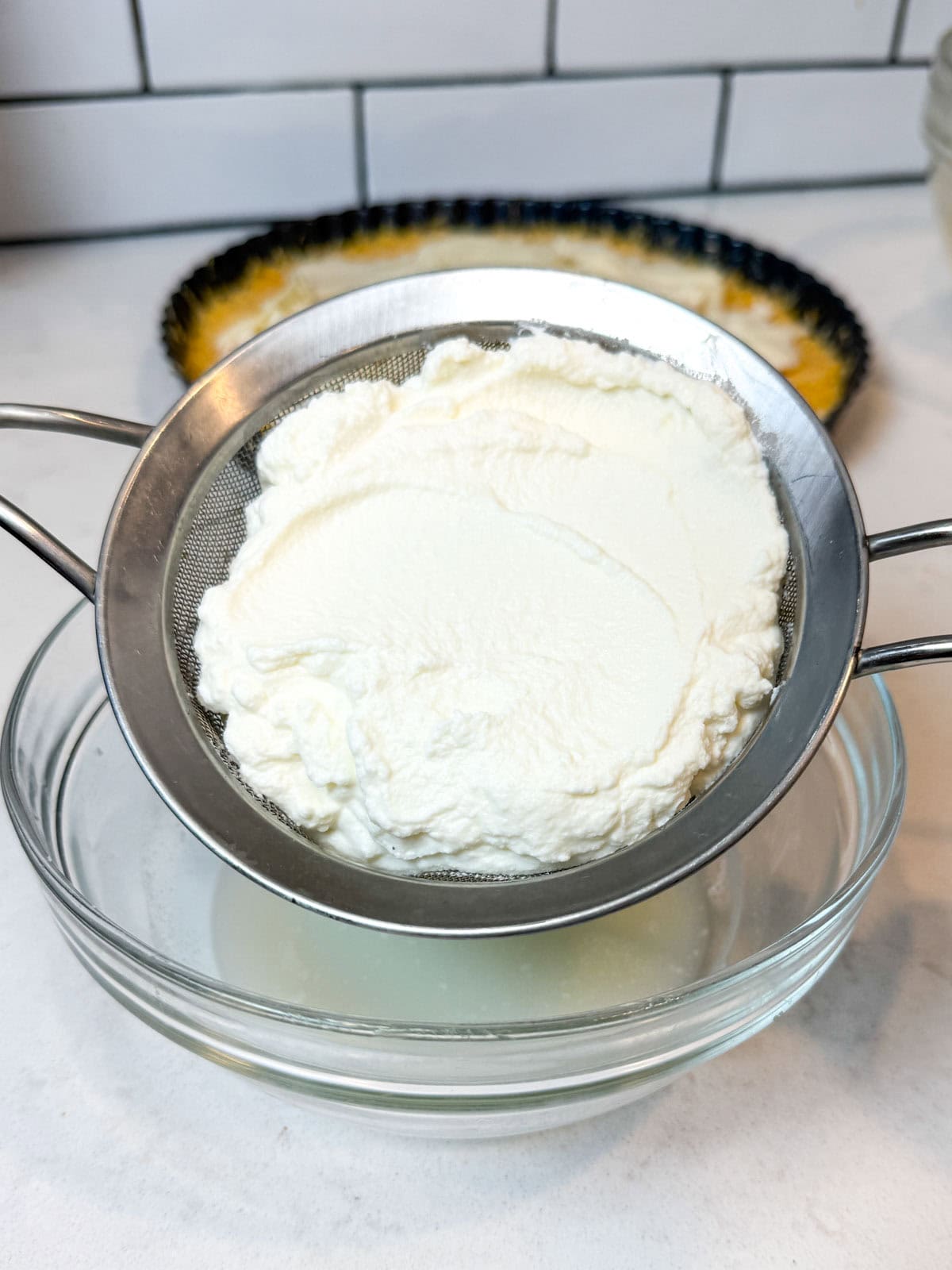 Add the ricotta to a fine strainer to strain excess liquid.