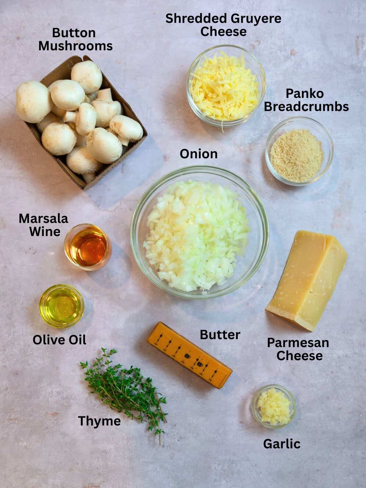 Ingredients for French onion stuffed mushrooms, including Gruyere cheese, butter, thyme and Marsala wine.