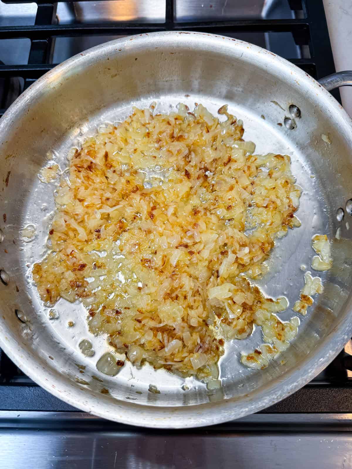 About halfway through caramelizing the onions, they will deep in color but still need more sautéing until it reaches a deep brown color.