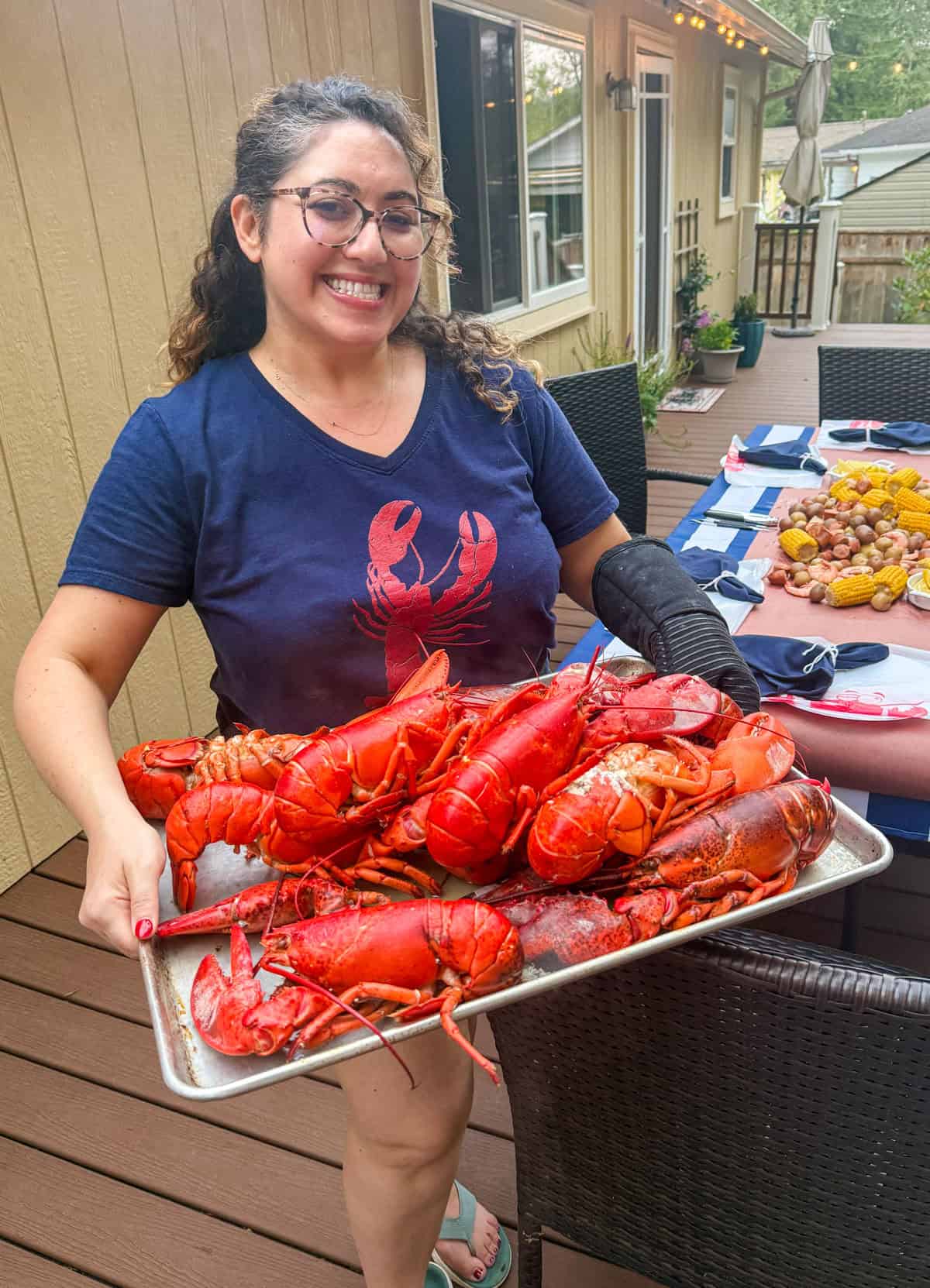 Samantha Ferraro holding a platter of cooked whole Main lobsters for the lobster boil.