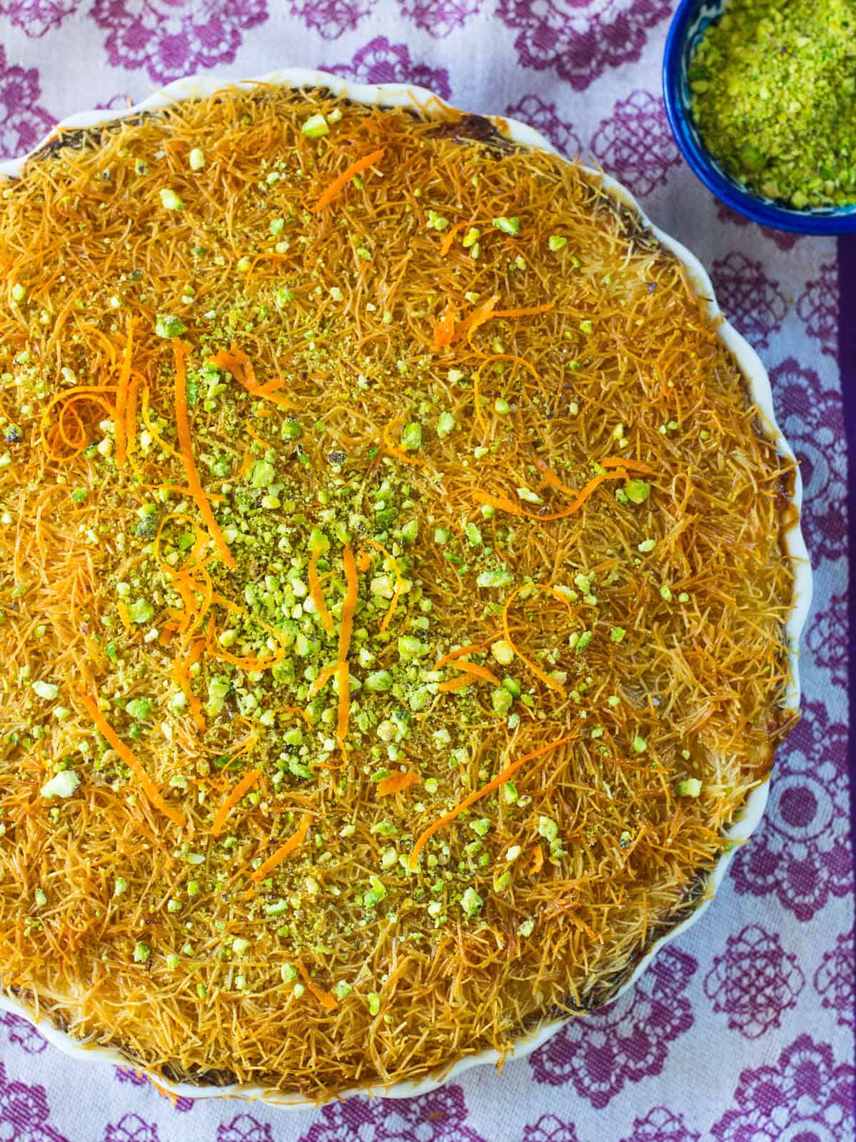 Kanafe filled with melty cheese and topped with chopped pistachios.