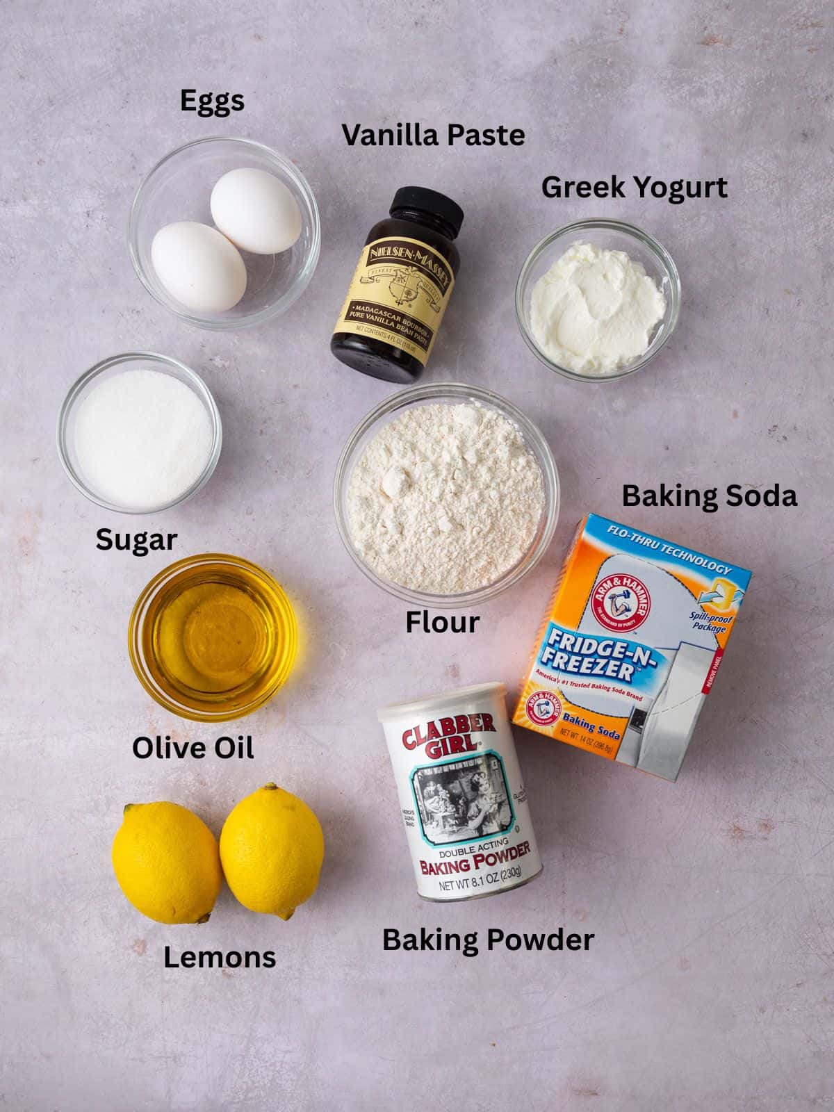 Ingredients for lemon olive oil cake, including banilla paste, sugar, eggs and yogurt.