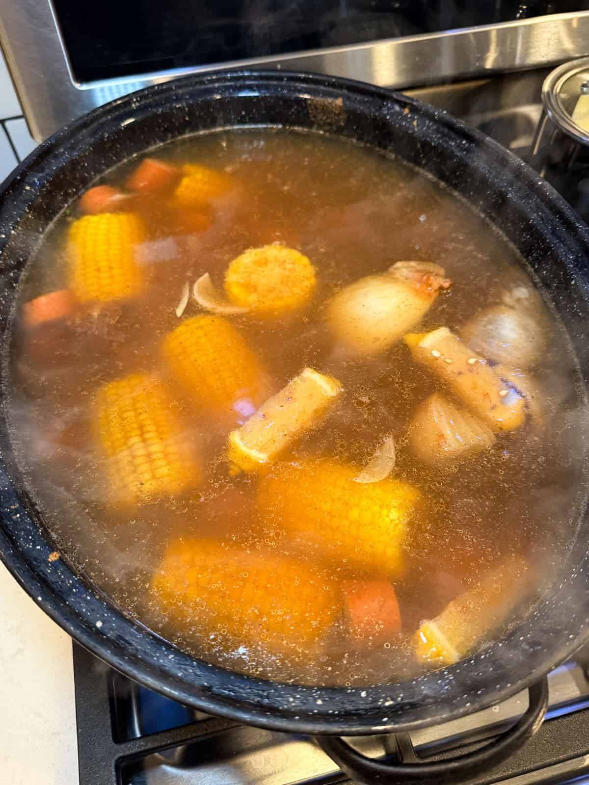 Lobster boil stock with corn, potatoes, sausage and seasoned with Old Bay.