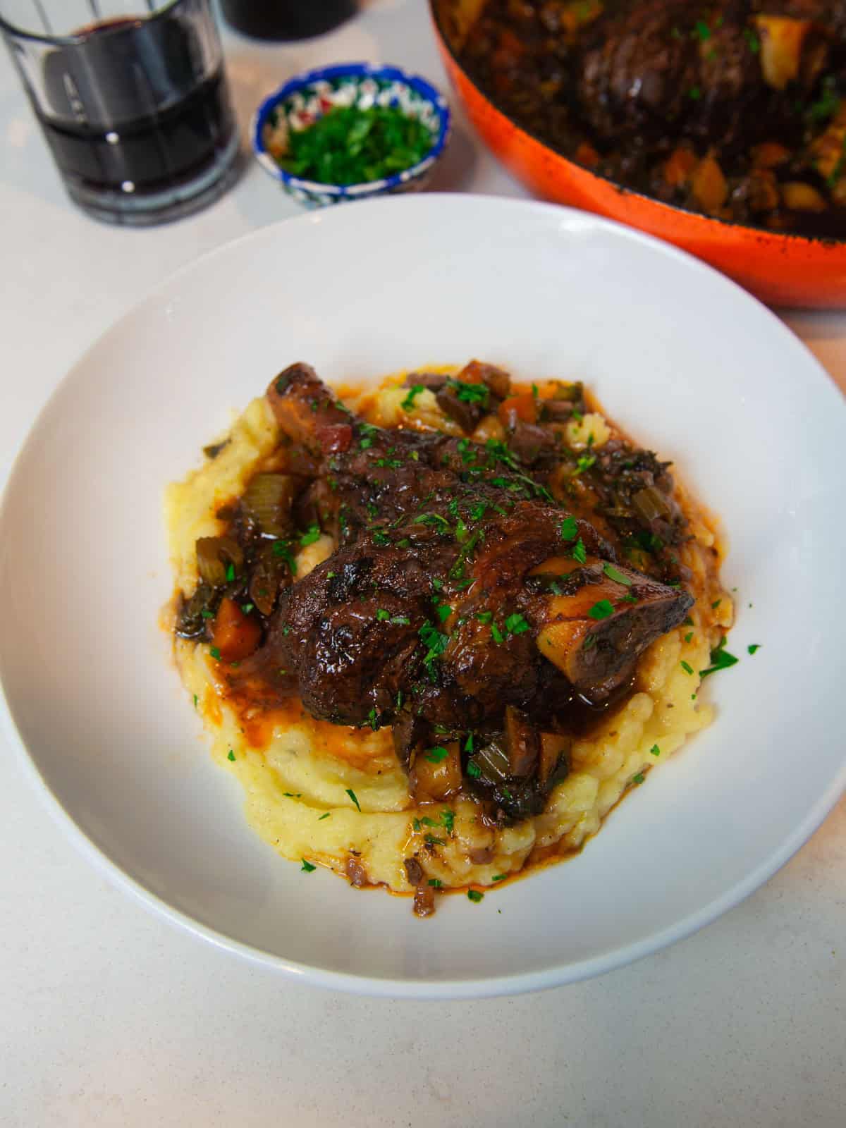 Greek braised lamb shanks with red wine and cinnamon served over creamy polenta.