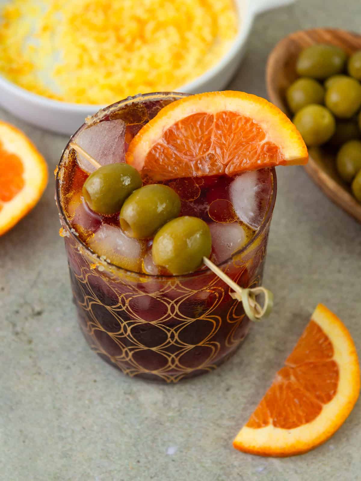 Lambrusco spritz with olives and orange slice.