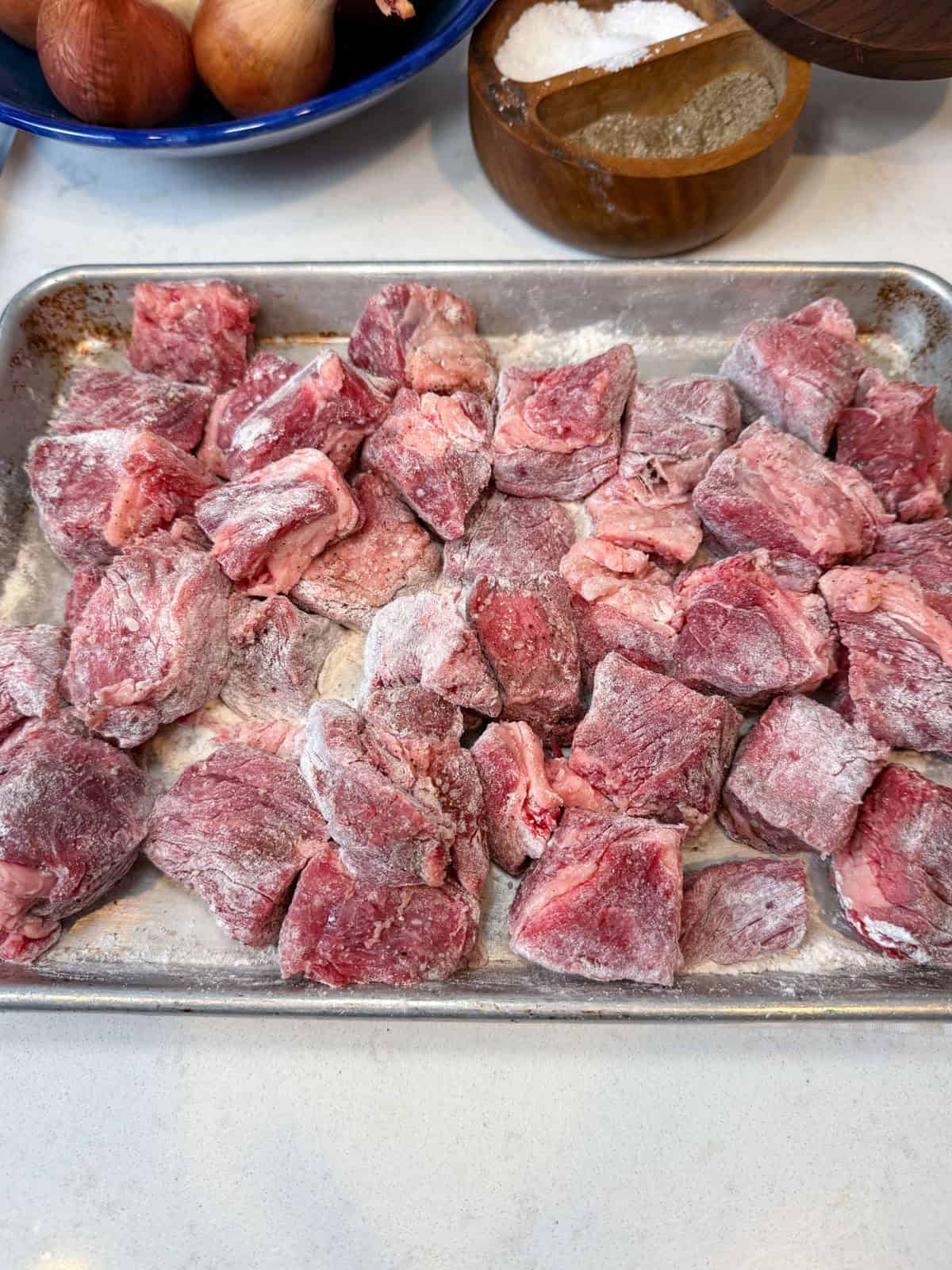 Pat the beef dry, then season with salt and pepper and lightly coat with flour — this helps it brown beautifully when seared.
