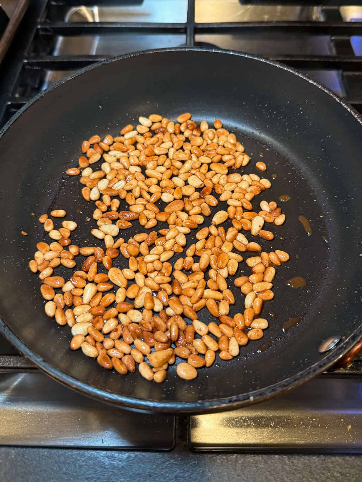 Toast pine nuts in a pan with ghee until lightly golden.