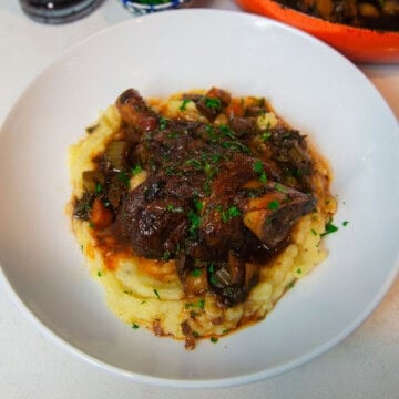 Tender wine braised lamb shanks with cinnamon and herbs.