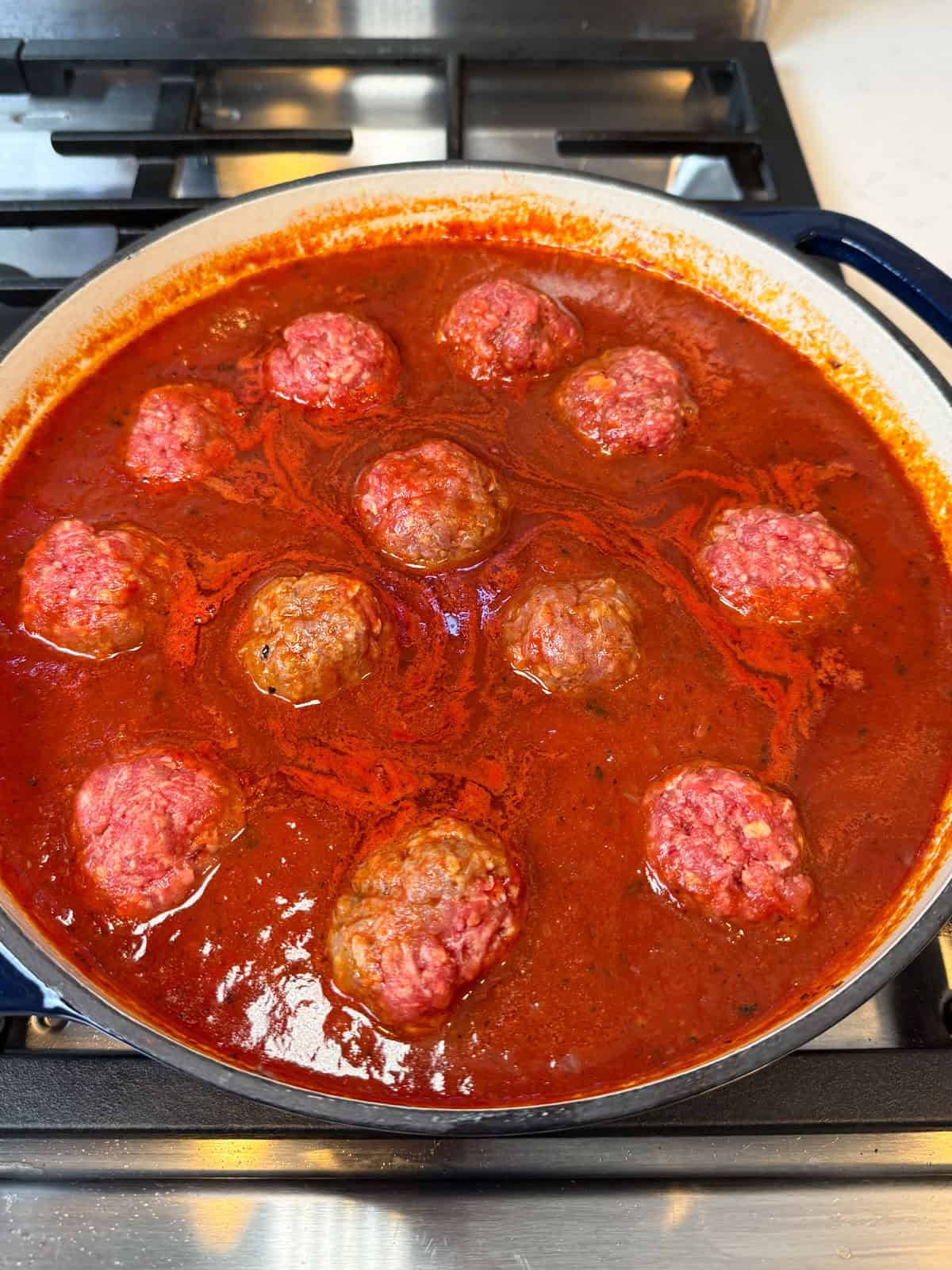 Add the beef meatballs to the sweet and sour tomato sauce and simmer until the meatballs are just cooked through.