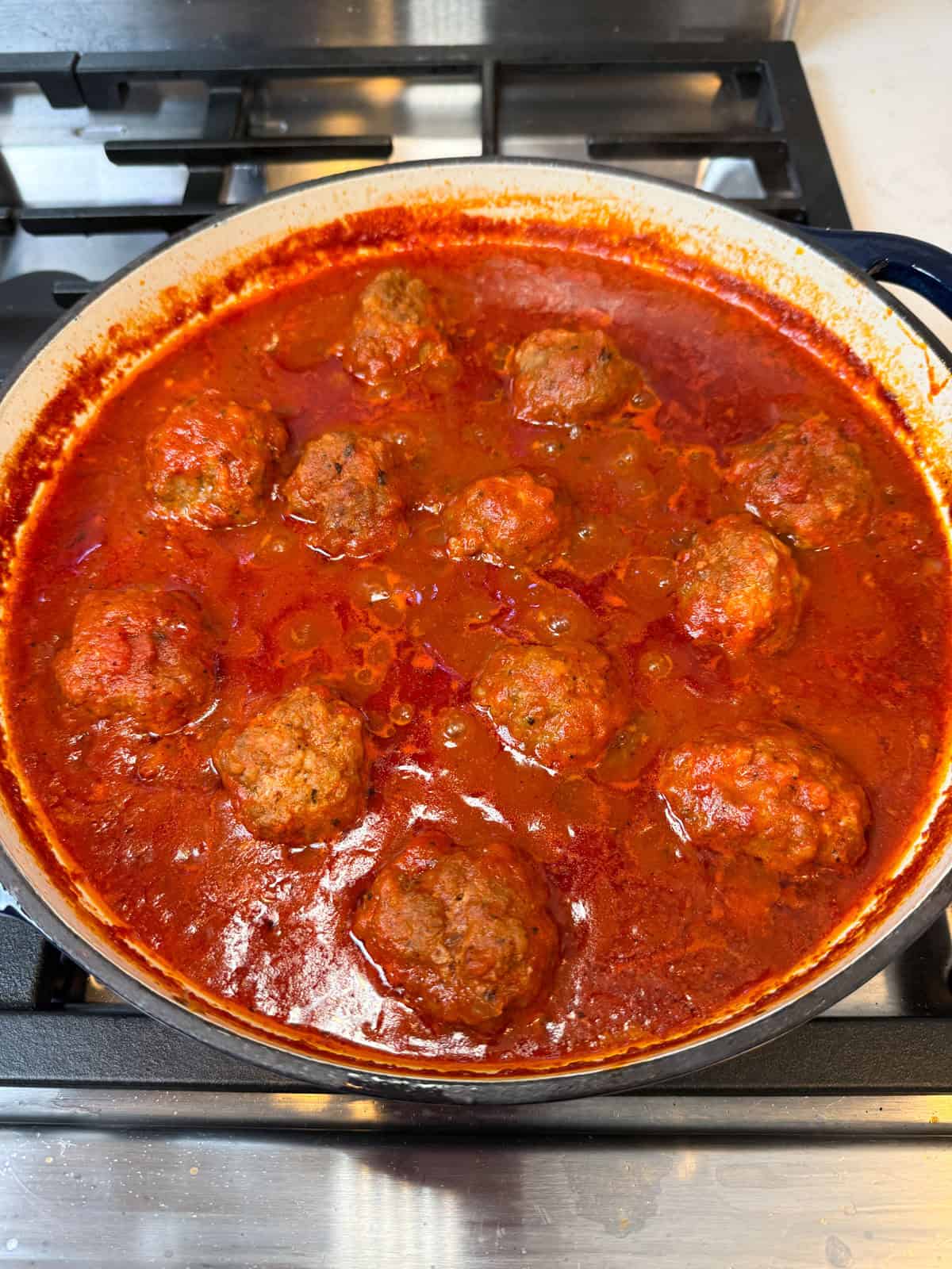 Simmer the meatballs in the tomato sauce until the sauce has reduced slightly and the meatballs are just cooked through and tender.