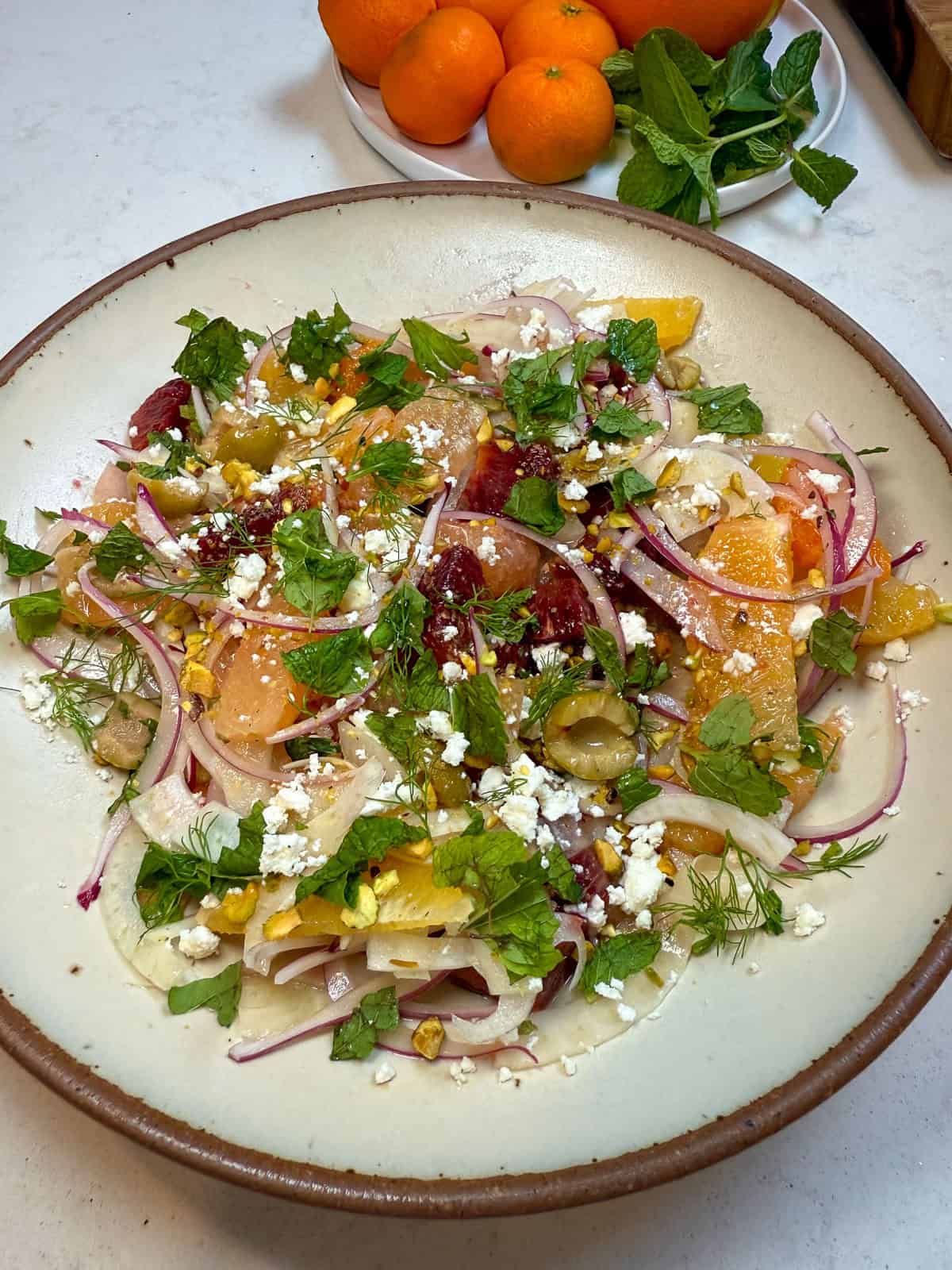 Garnish the citrus fennel salad with chopped pistachios and fresh mint before serving.