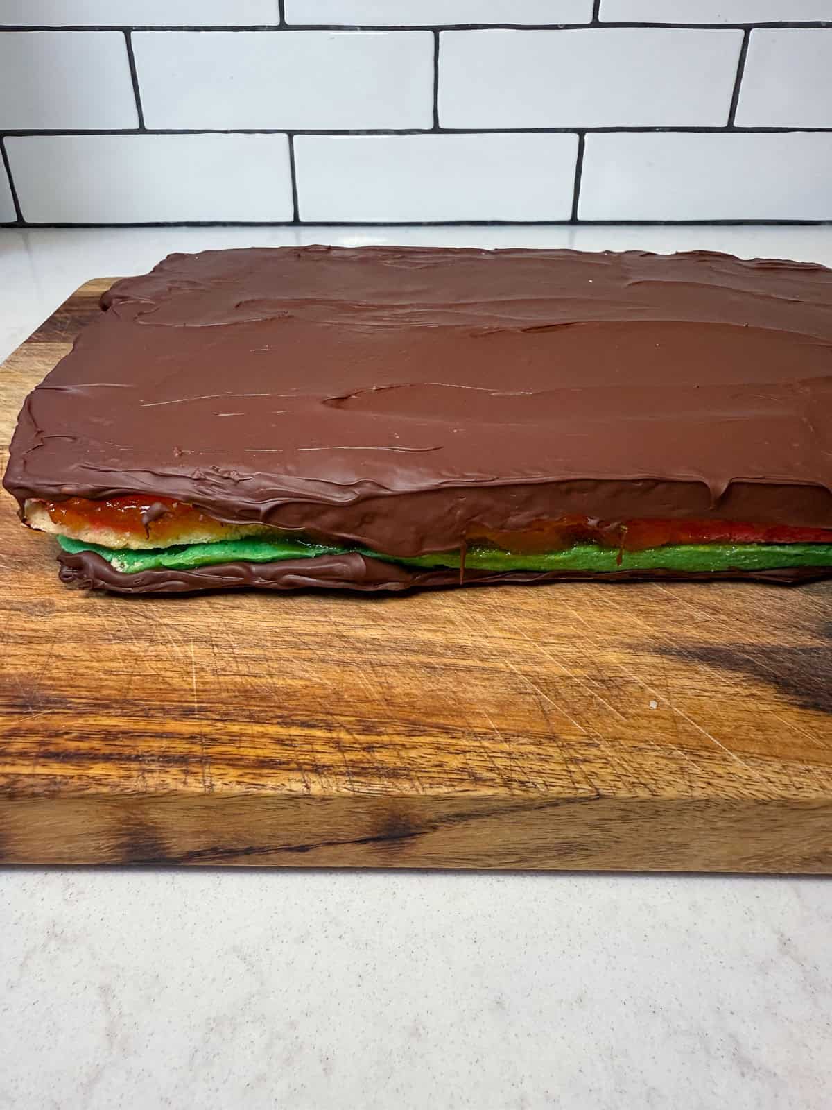 Chill the Italian rainbow cookies in the fridge to harden the chocolate, then repeat on the other side so both sides are coated ith a thin layer of chocolate.