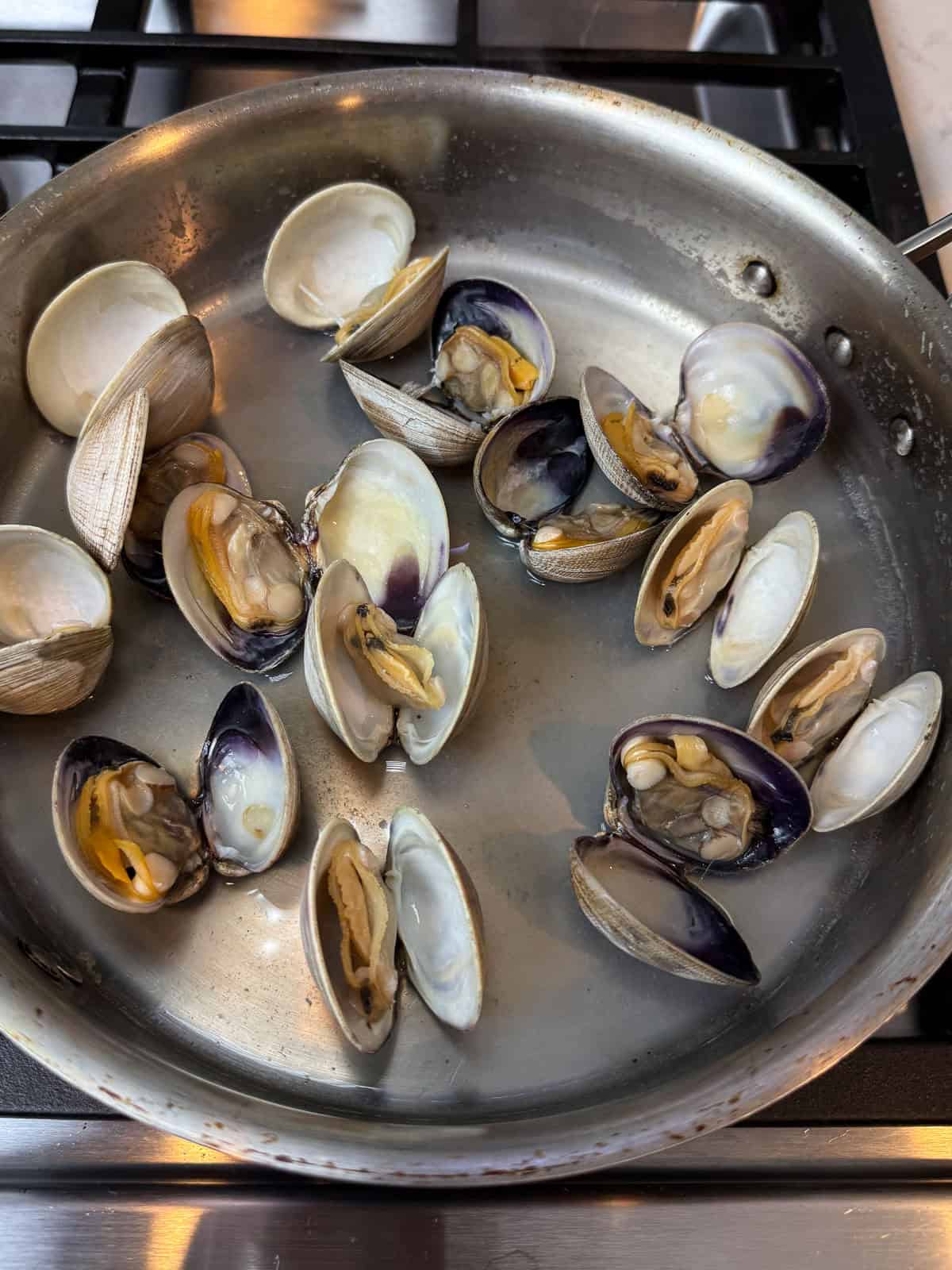 Steam the fresh clams in white wine until they open up.