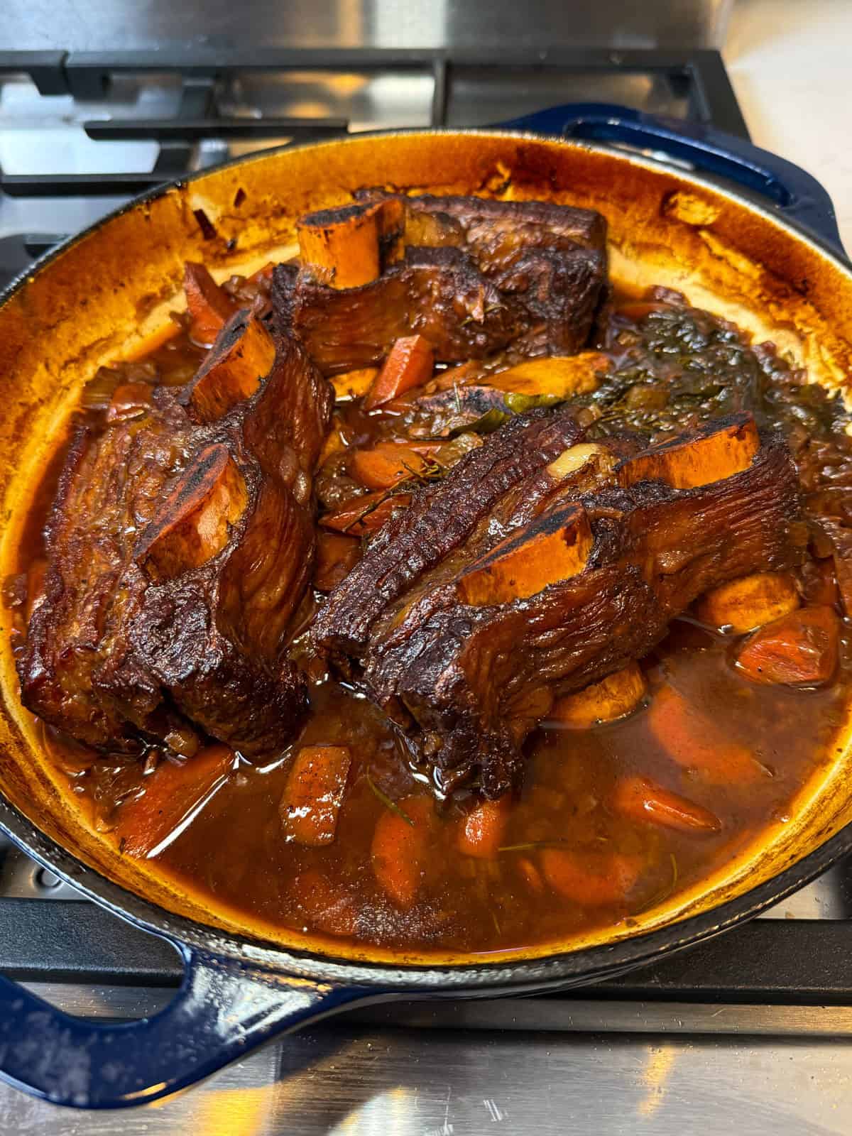 Cook the pomegranate short ribs in the oven until the sauce reduces and meat is tender and starts to fall off the bone.