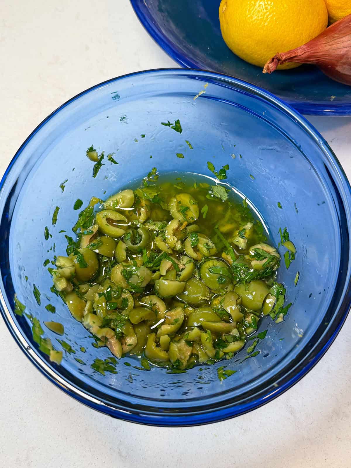Add the roughly chopped olives to a bowl along with fresh herbs and olive oil, lemon zest and juice and toss to combine.