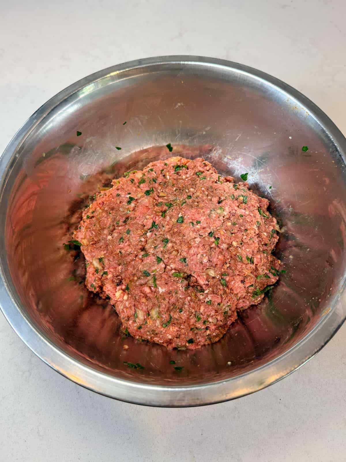 Mix the ground beef, chopped herbs and onions and spices together. This will be the ground beef mixture for the arayes.
