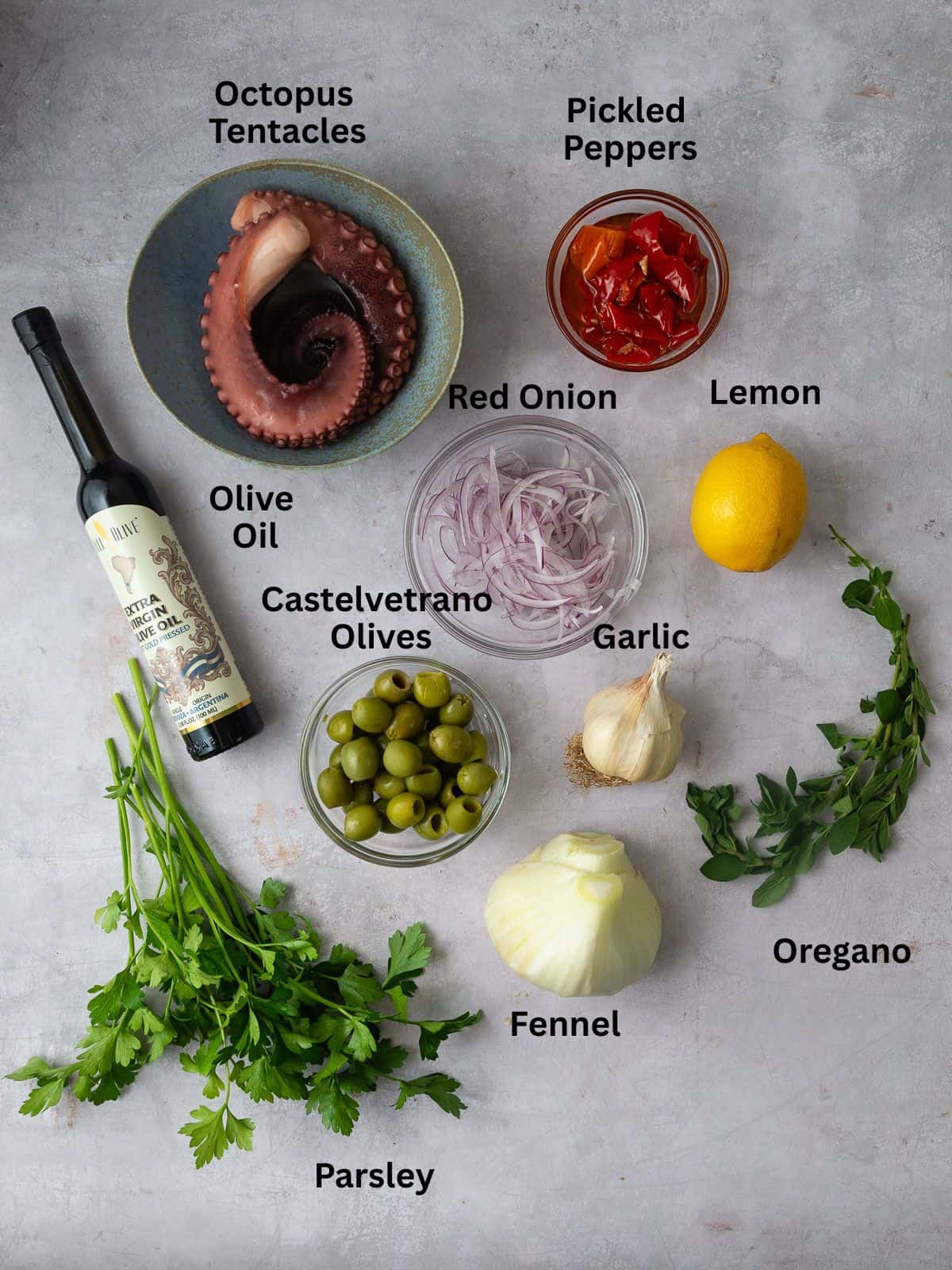 Ingredients for Mediterranean octopus salad with pickled peppers, green olives, fennel and fresh herbs.