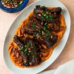 Tender Pomegranate short ribs are slightly tangy and savory and served over creamy sweet potatoes.