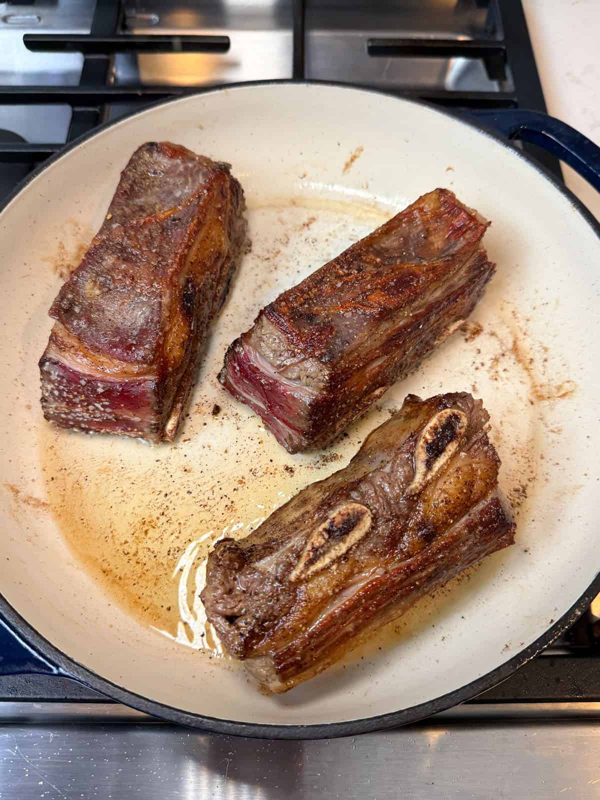 In a wide Dutch oven drizzled with olive oil, sear the short ribs on all sides until deeply browned.