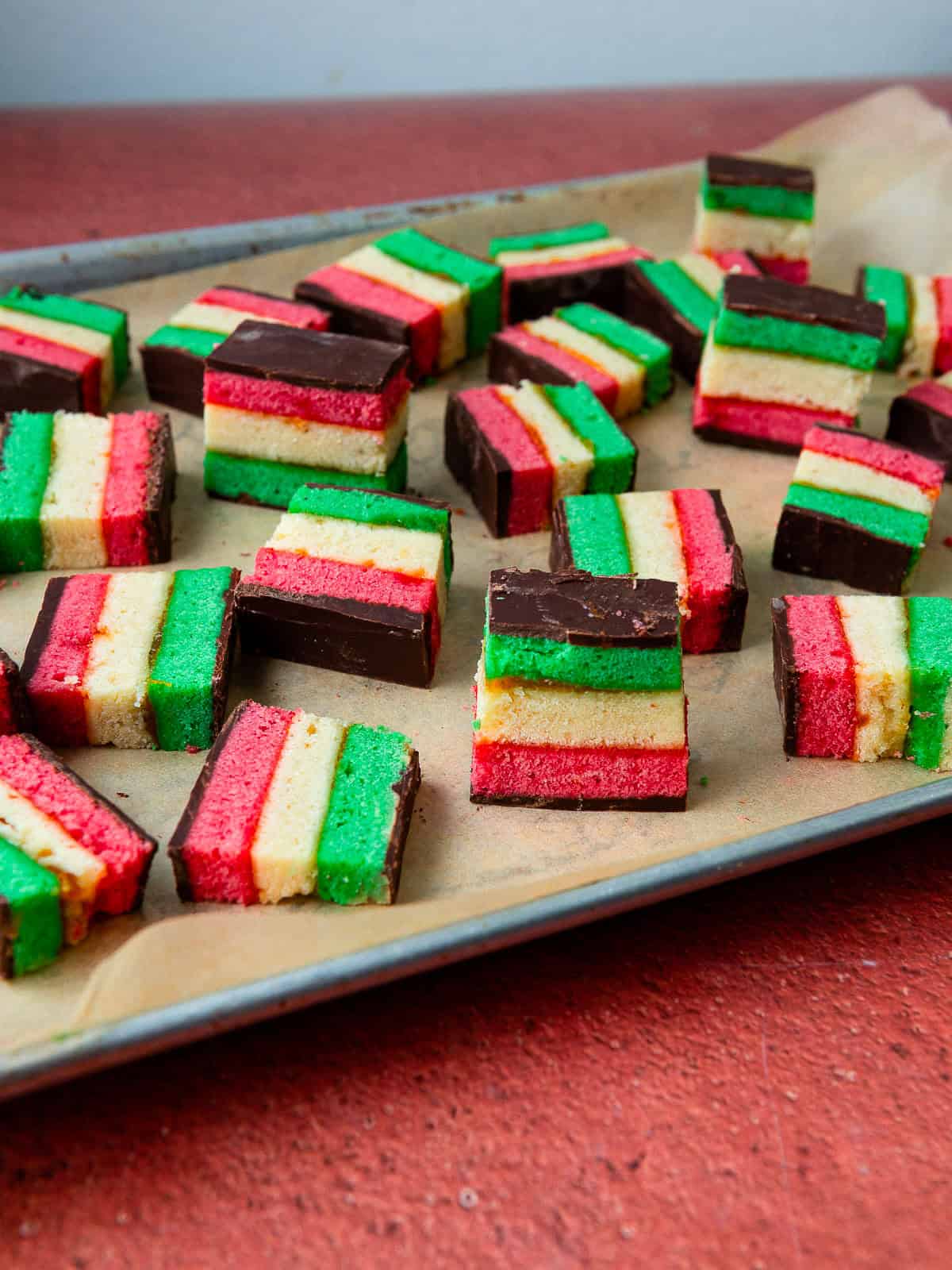 Seven layer Italian rainbow cookies with apricot jam and coated in a thin layer of chocolate.