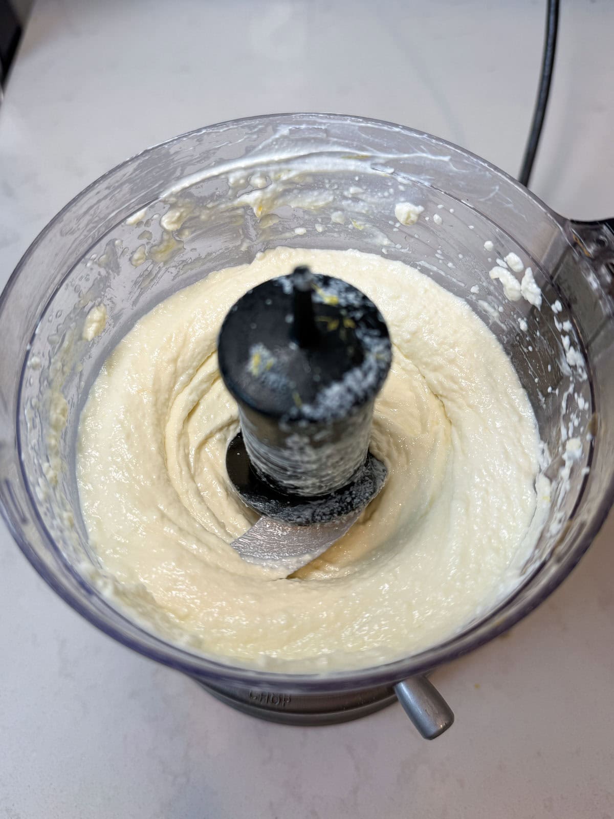 To a small food processor, add the feta cheese, yogurt, honey, olive oil and lemon zest and puree until the mixture is smooth.