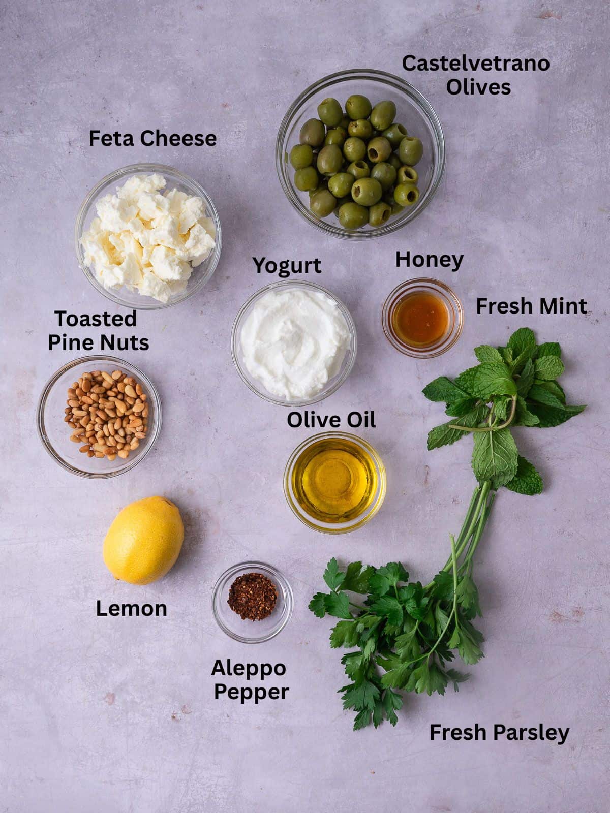 Ingredients for whipped feta, including yogurt, honey, lemon and olives.