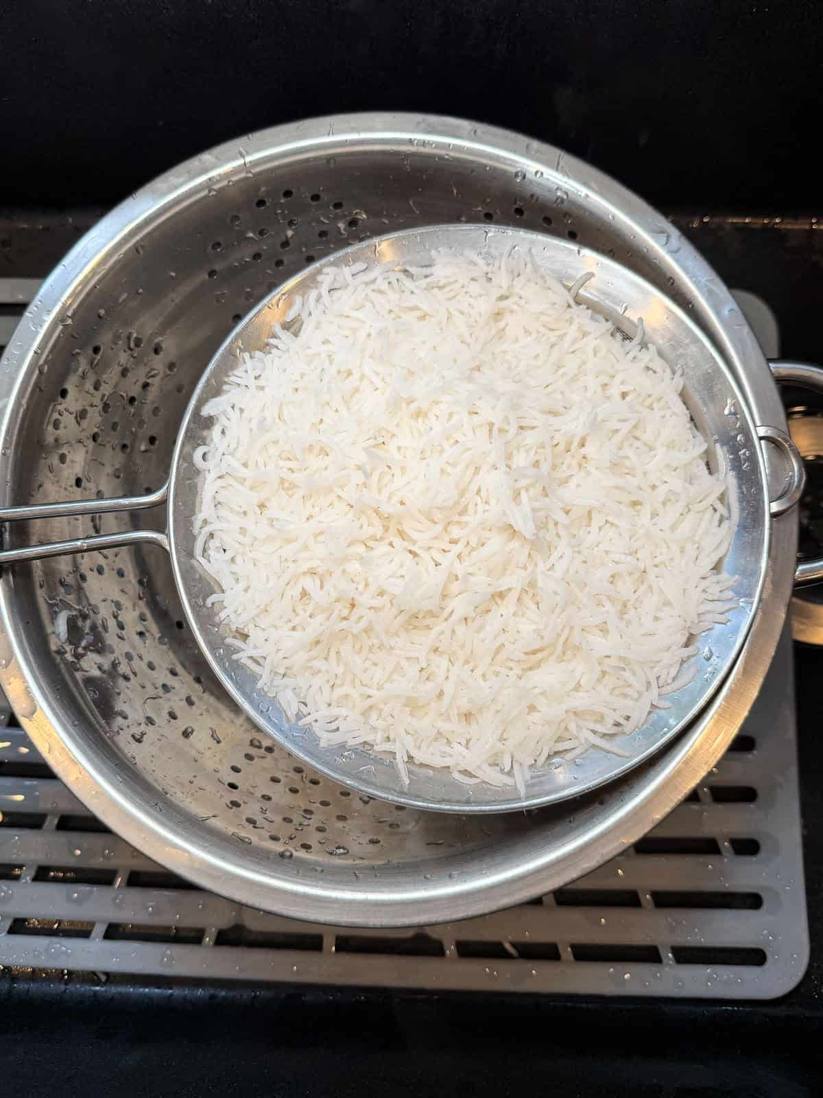Drain the par-cooed basmati rise and rinse under cool water to stop the cooking.