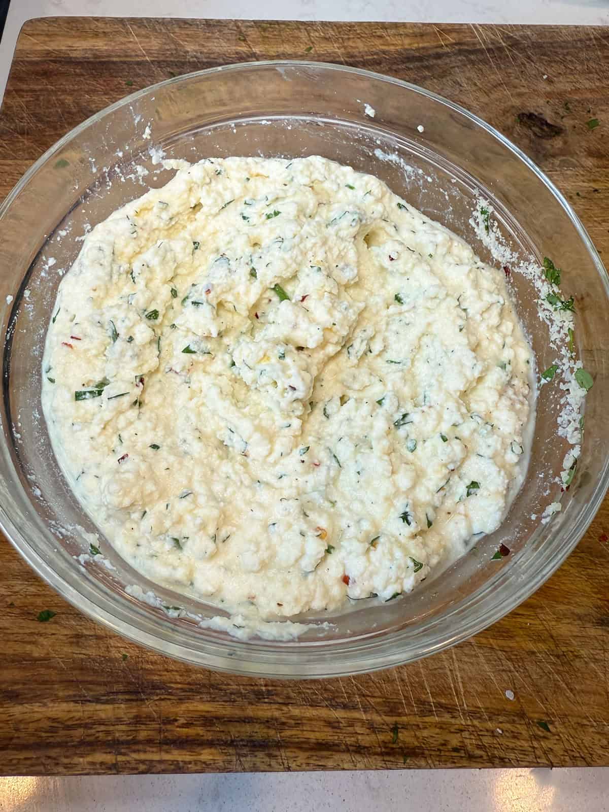 Mix the ricotta mixture for the zucchini lasagna. Combine ricotta cheese, one egg, fresh herbs and parmesan cheese and mix well.