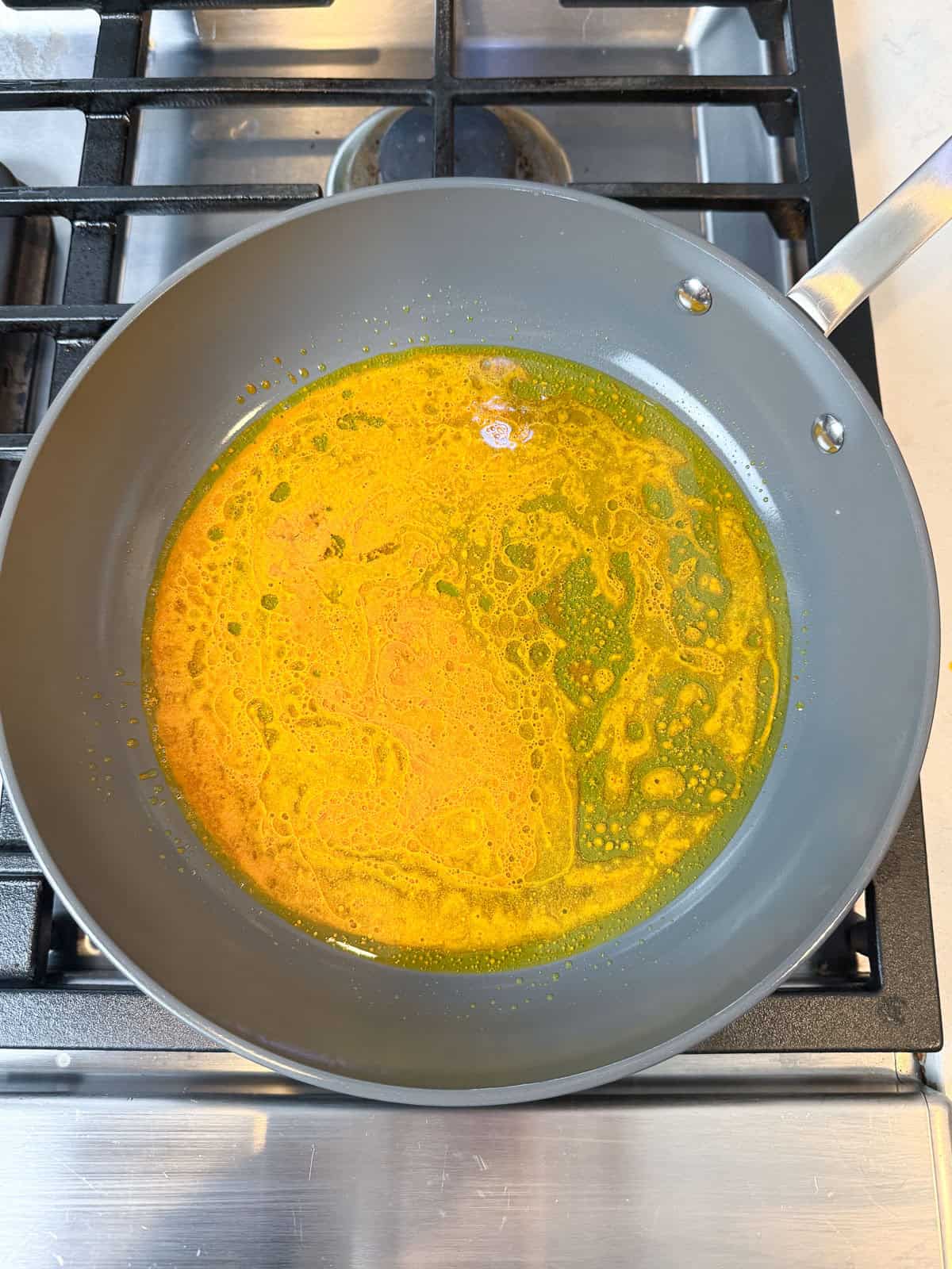 Add olive oil, saffron water and turmeric to a wide skillet and mix to even distribute.