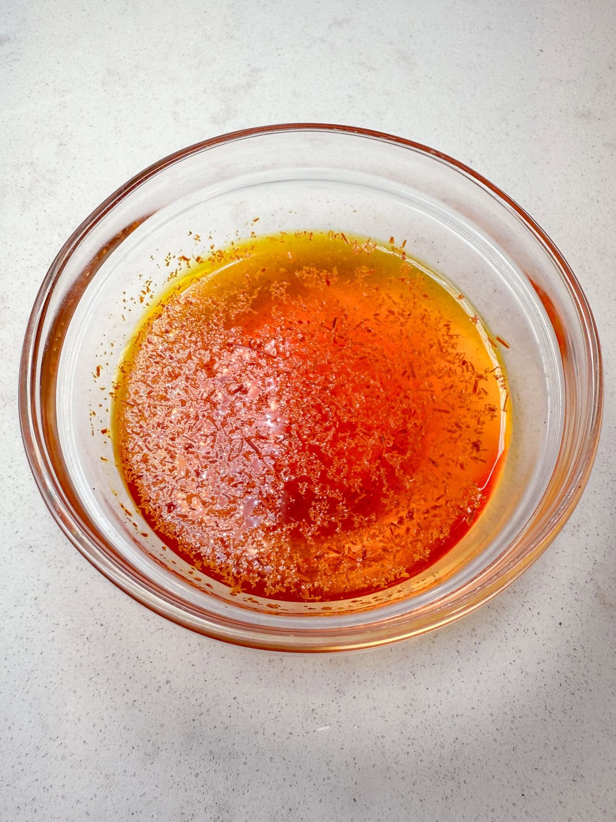 Steep ground saffron in a few tablespoons of warm water to bloom.