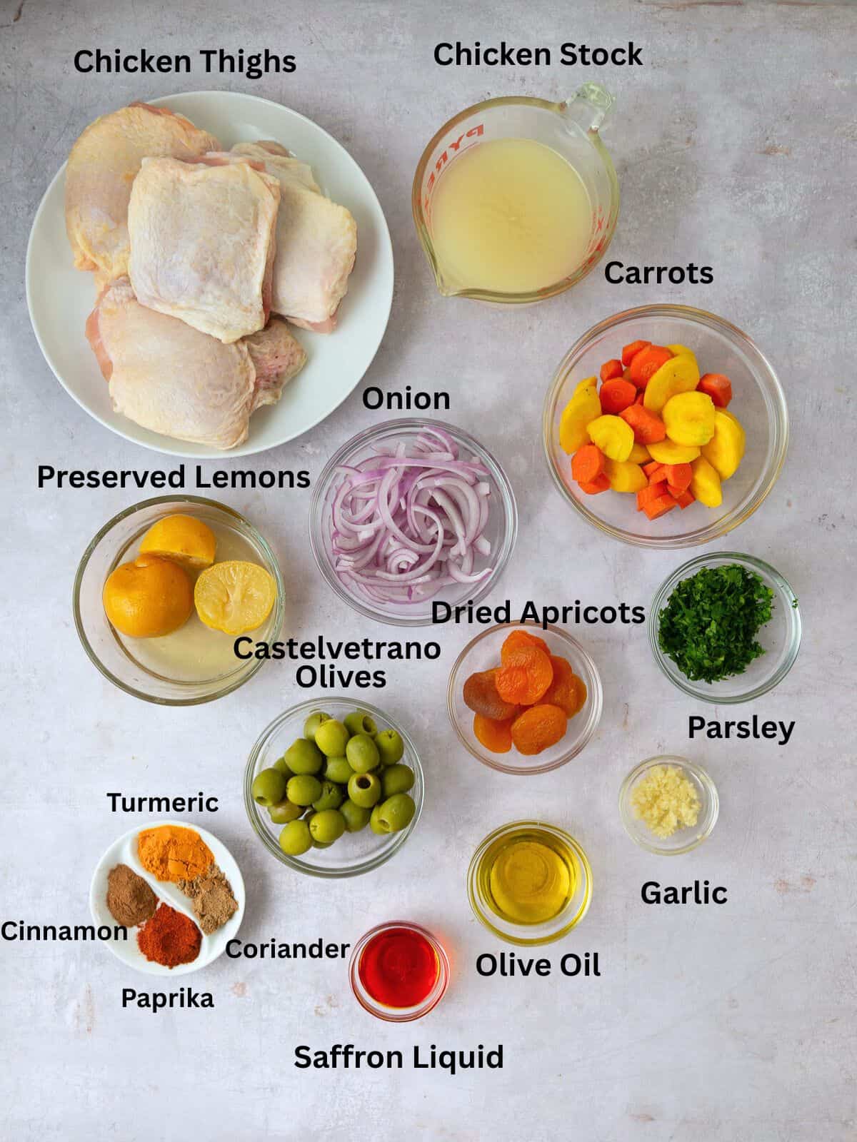 Ingredients for chicken tagine including preserved lemons, olives, dried apricots and spices.