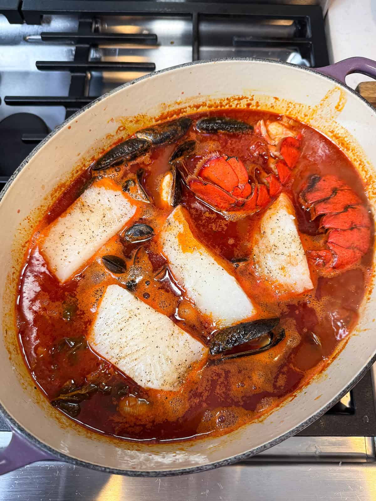 Nestle in the halibut fillets a few minutes after the clams and mussels start cooking in the cioppino.