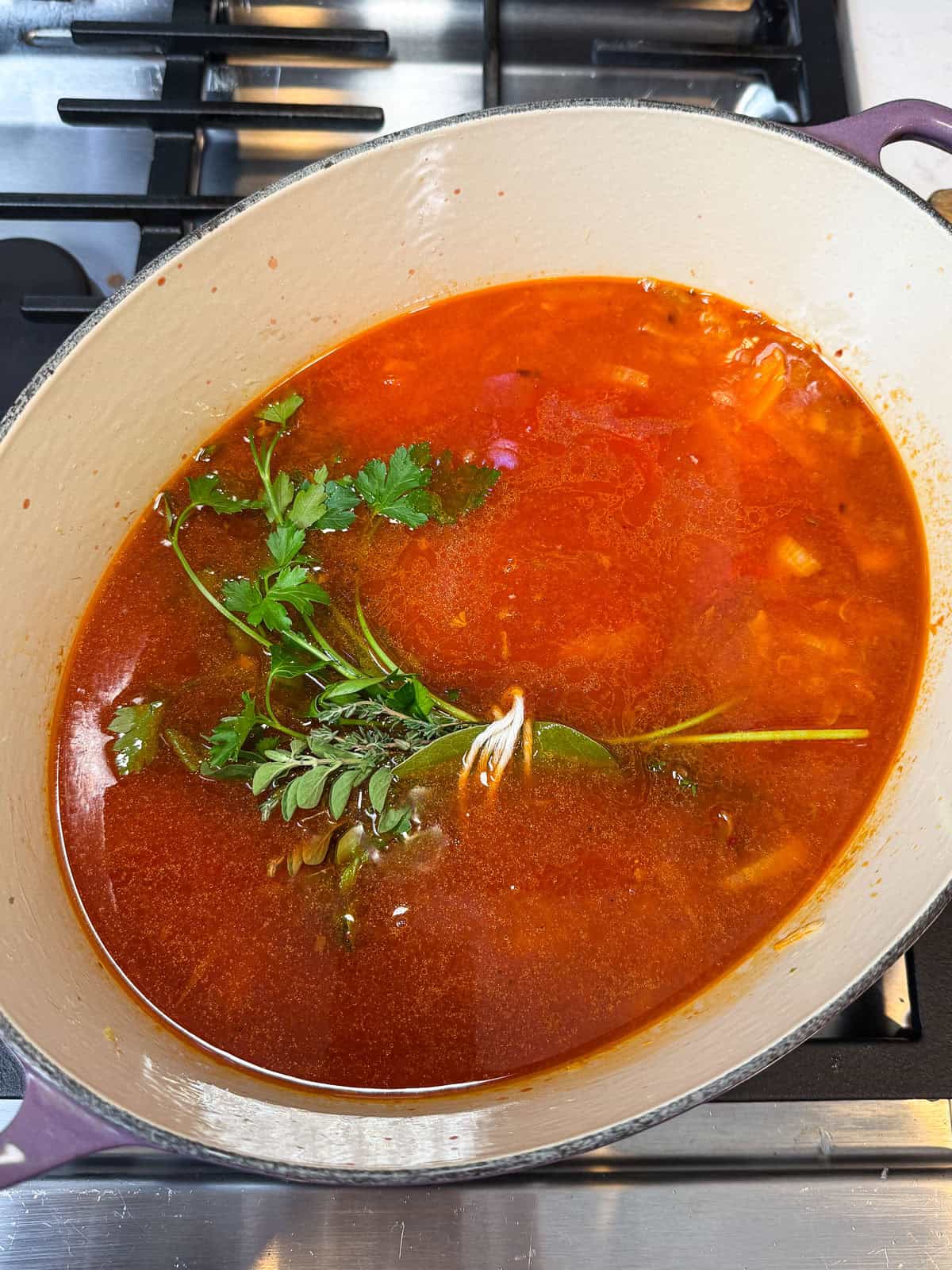 Add the herb bundle to the cioppino base.