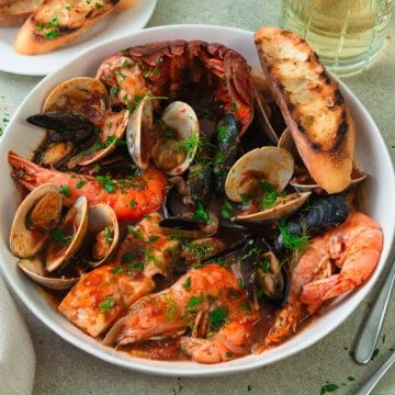 This cioppino recipe is full of abundant seafood with clams, mussels and lobster in a flavorful tomato broth.