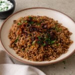 Lebanese mujadara is a vegan lentil and rice dish with fried onions and warm spices.