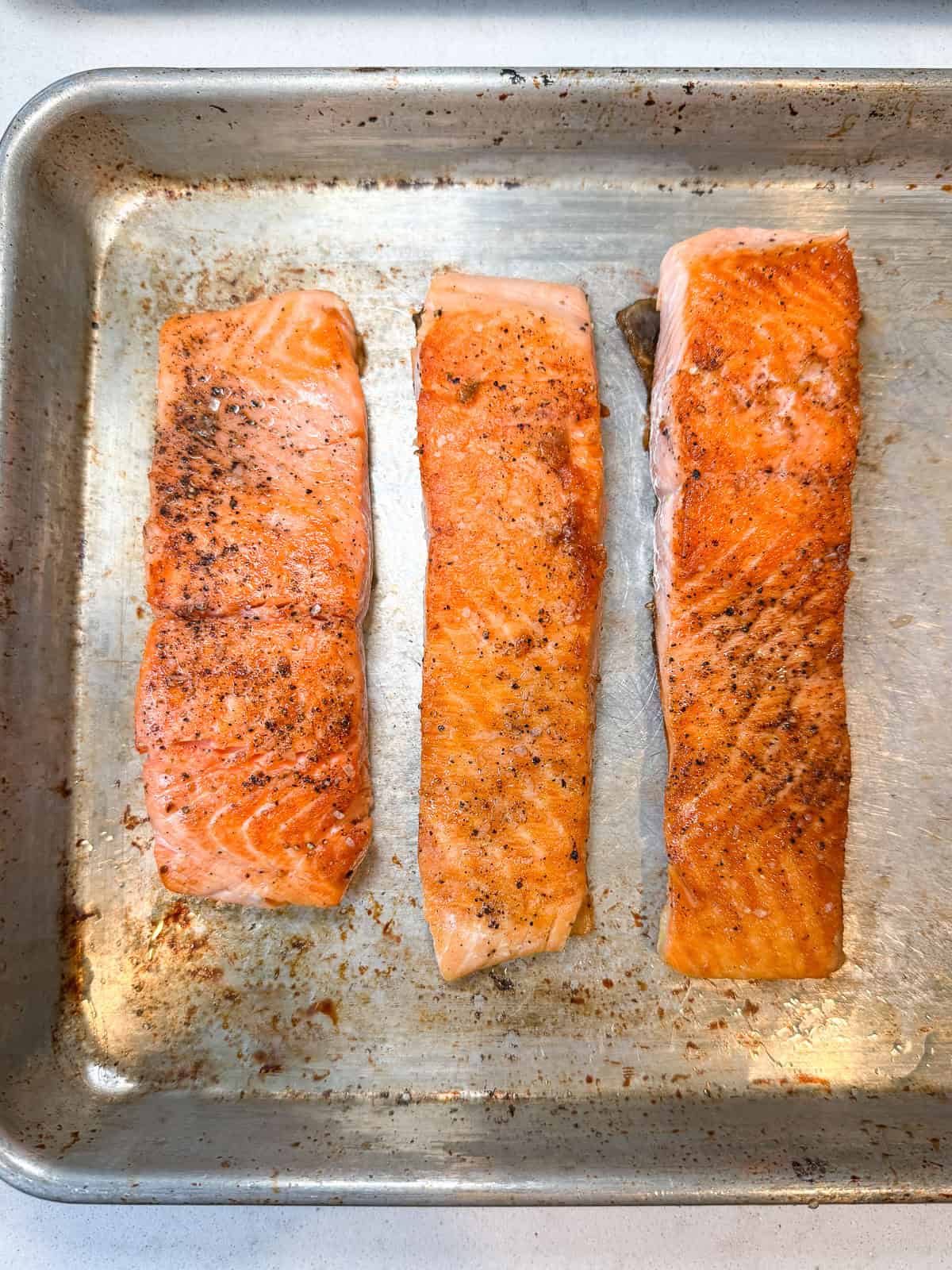 Once the salmon filets are seared, set them aside and cover with foil to keep warm.