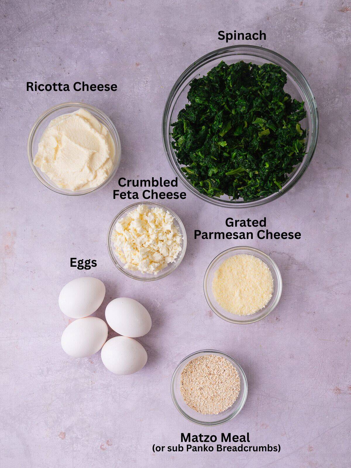 Ingredients for Sephardic spinach pie with thawed spinach, ricotta cheese, eggs, feta cheese and grated Parmesan cheese.