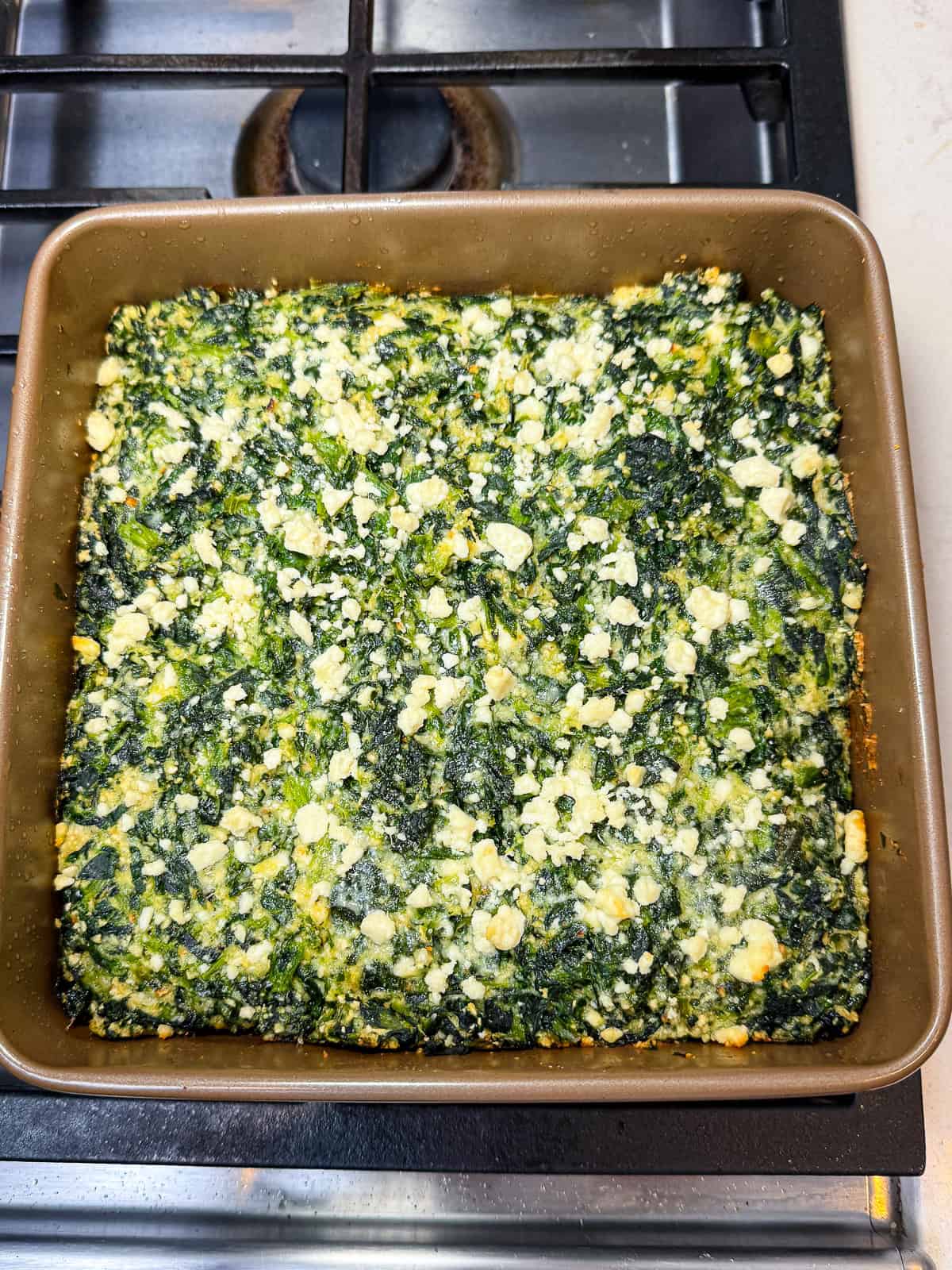 Bake the spinach and feta pie until lightly golden on top.